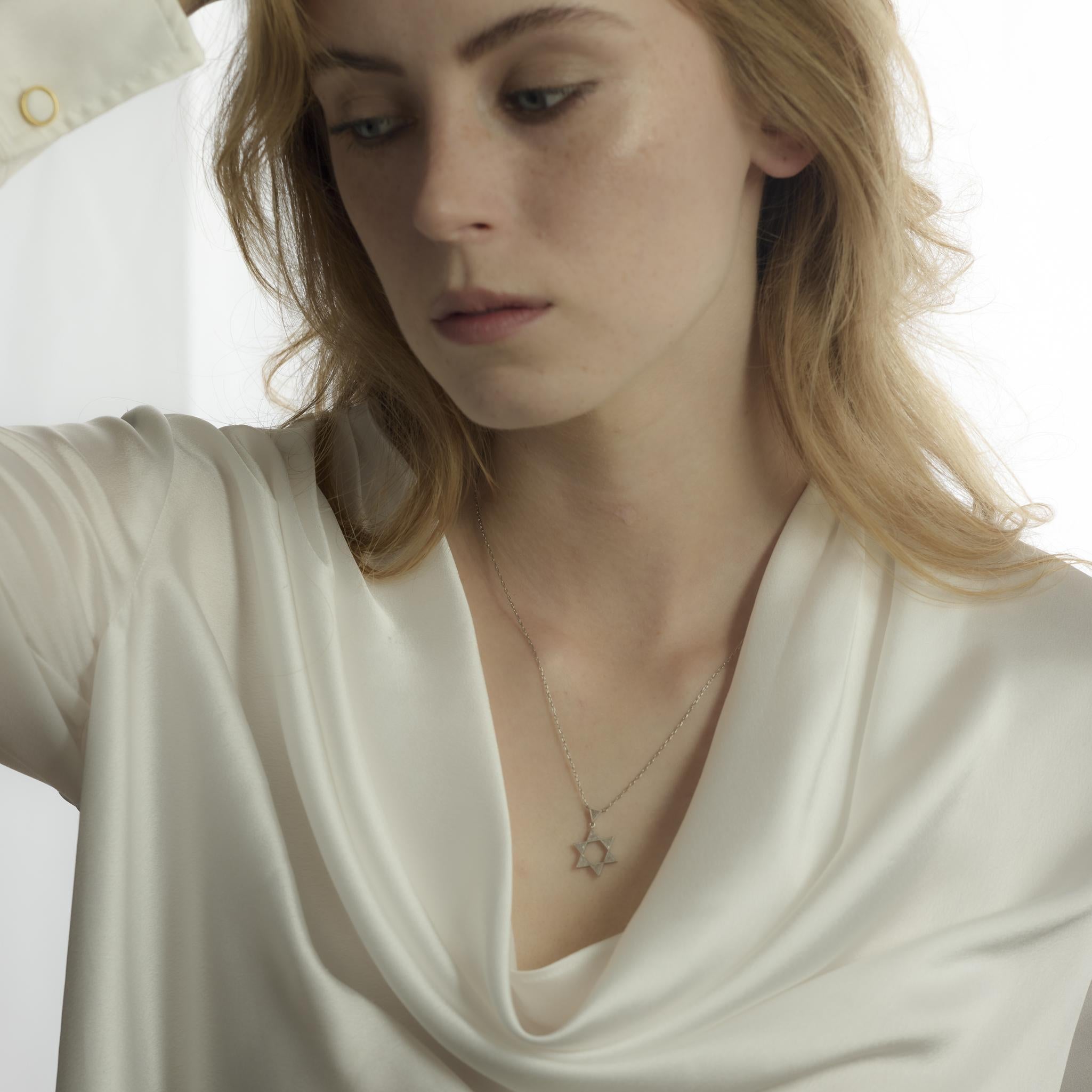 Este collar vintage de platino de la década de 1980 presenta siete diamantes de talla trillante que suman aproximadamente 0,70 quilates. Los diamantes, de color F-G y claridad SI, añaden un brillo moderno y anguloso al elegante diseño de 20