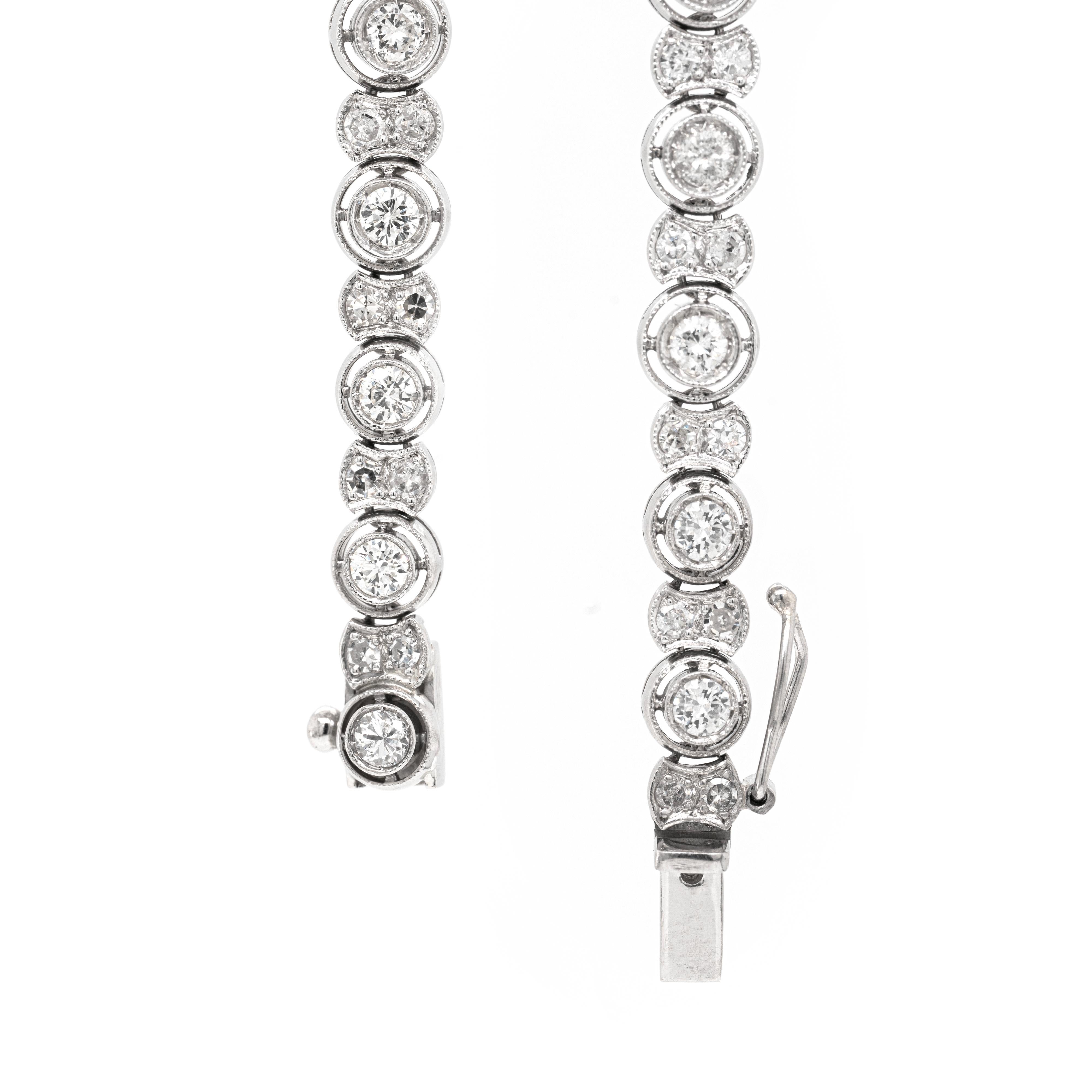 Bei diesem Vintage-Tennisarmband wechseln sich Glieder mit einem einzelnen runden Diamanten im Brillantschliff in einer durchbrochenen Fassung und kleinere Glieder mit zwei Diamanten im Achtschliff ab, die alle in Platin gefasst sind. Mit einem