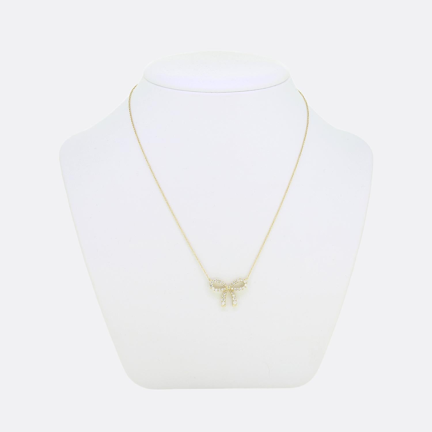 Here we have a lovely diamond necklace. This vintage piece has been crafted from 18ct yellow gold into the shape of a looped ribbon and adorned with a single row of round brilliant cut diamonds around the entire frame. This dazzling bow is then
