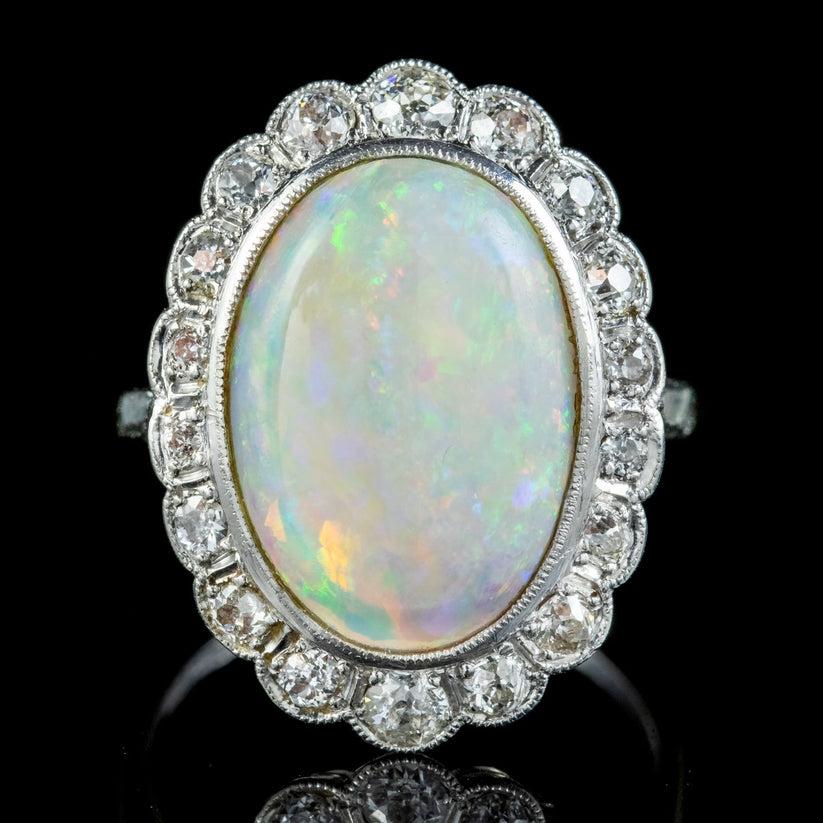 A magnificent Vintage statement ring from the early 20th Century adorned with a spectacular natural Opal in the centre weighing approx. 6ct and framed by a halo of pave set Old European cut Diamonds (approx. 1ct total). 

The Opal is a kaleidoscope