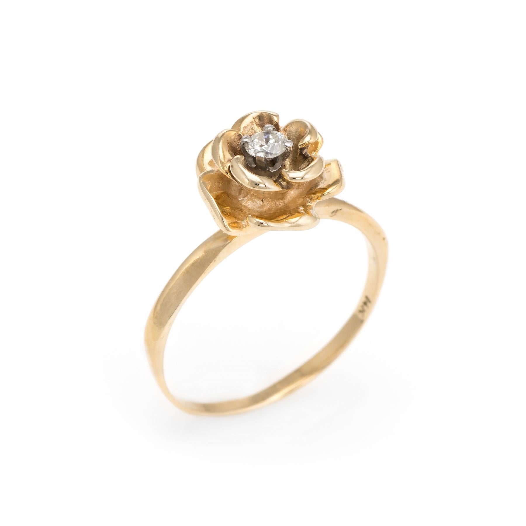 Finely detailed vintage flower ring, crafted in 14 karat yellow gold. 

Centrally mounted round brilliant cut diamond is estimated at 0.15 carats (estimated at I-J color and SI2 clarity).
  
The diamond is set into a charming mount depicting a rose