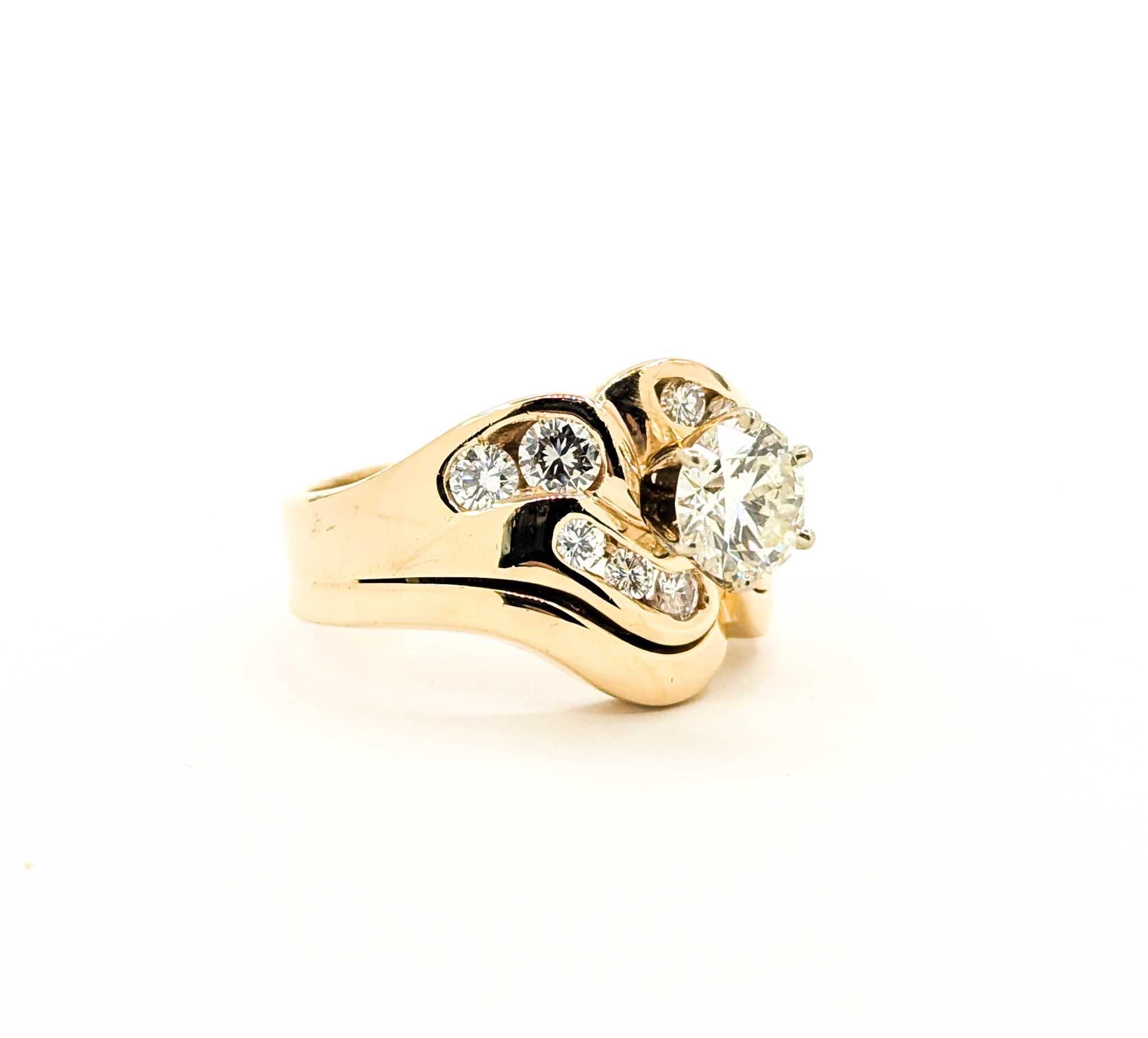 This striking vintage ring set features a brilliant 1.35 carat round diamond at its center, accented by an additional 0.92 carats of round brilliant diamonds, for a total of 2.27 carats. The diamonds are securely set in an elegant, flowing design