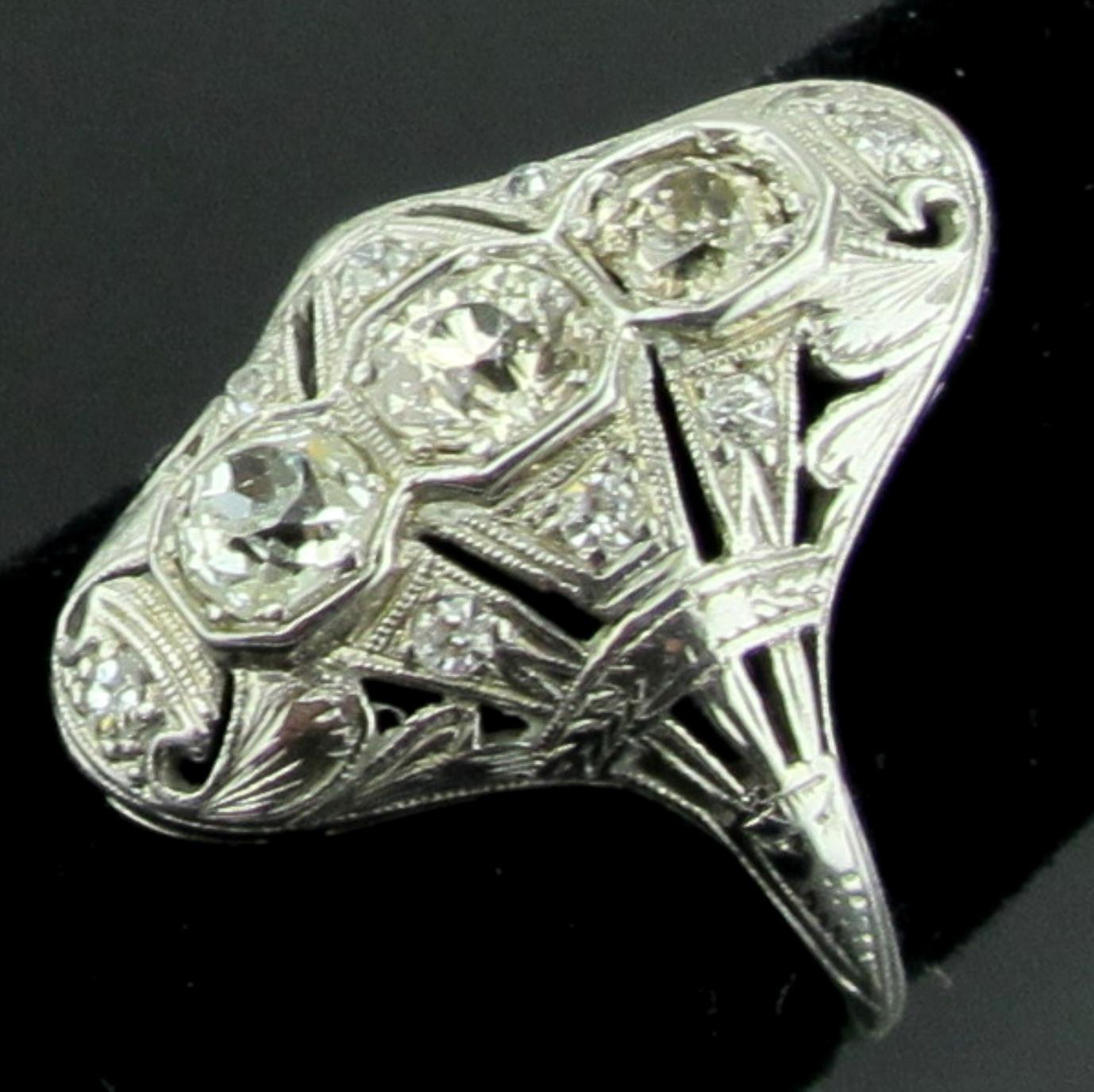 Circa 1920's vintage Diamond ring with 3 center Old European Cut diamonds weighing approximately 1 carat total, with 8 smaller Old European cut diamonds weighing approximately 0.25 carats.  Top is Platinum and shank is 18 karat white gold.  Ring