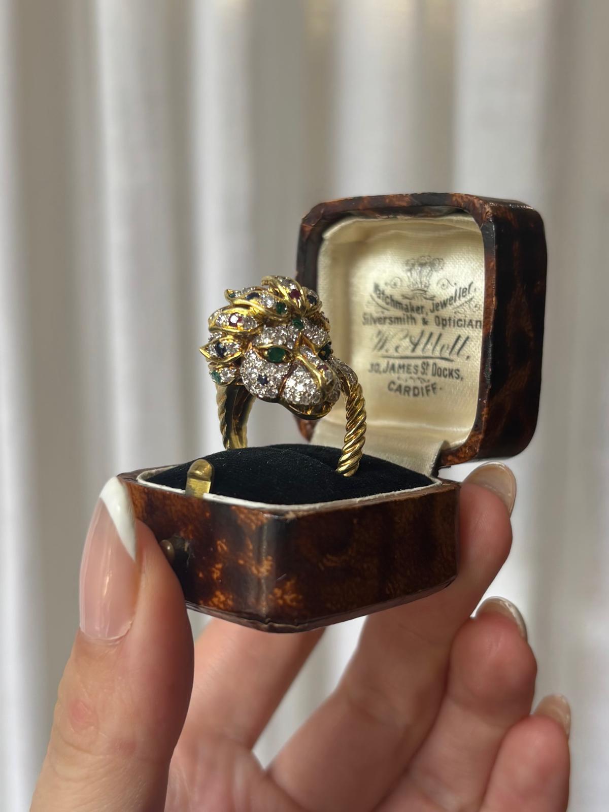 A highly unique vintage diamond, ruby, emerald and blue sapphire lion ring set in 18k yellow gold. 

The ring depicts a lion head motif, pave set with round brilliant cut diamonds, rubies, emerald and blue sapphires. The face of the lion has been