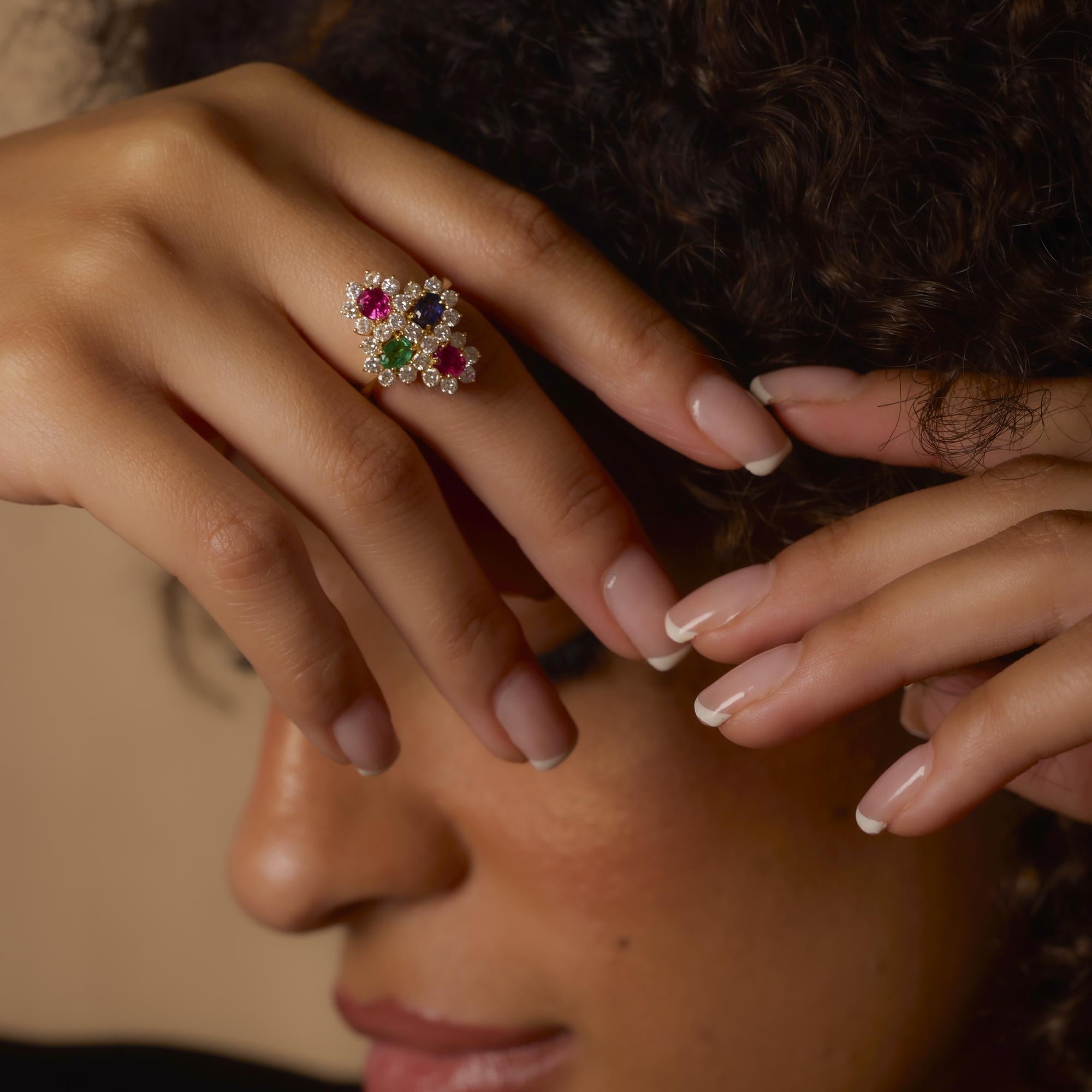 Cette bague vintage en or 18 carats met en valeur des rubis, des émeraudes et des saphirs vibrants avec des diamants brillants dans un design audacieux et coloré plein de caractère vintage.