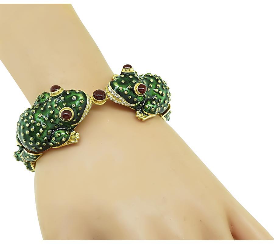 This is an amazing 18k yellow gold enamel frog bracelet. The bracelet is set with cabochon ruby and round cut diamond accents. The bracelet measures 30mm in width at the widest base and 7 inches in length. The bracelet weighs 66.2 grams.