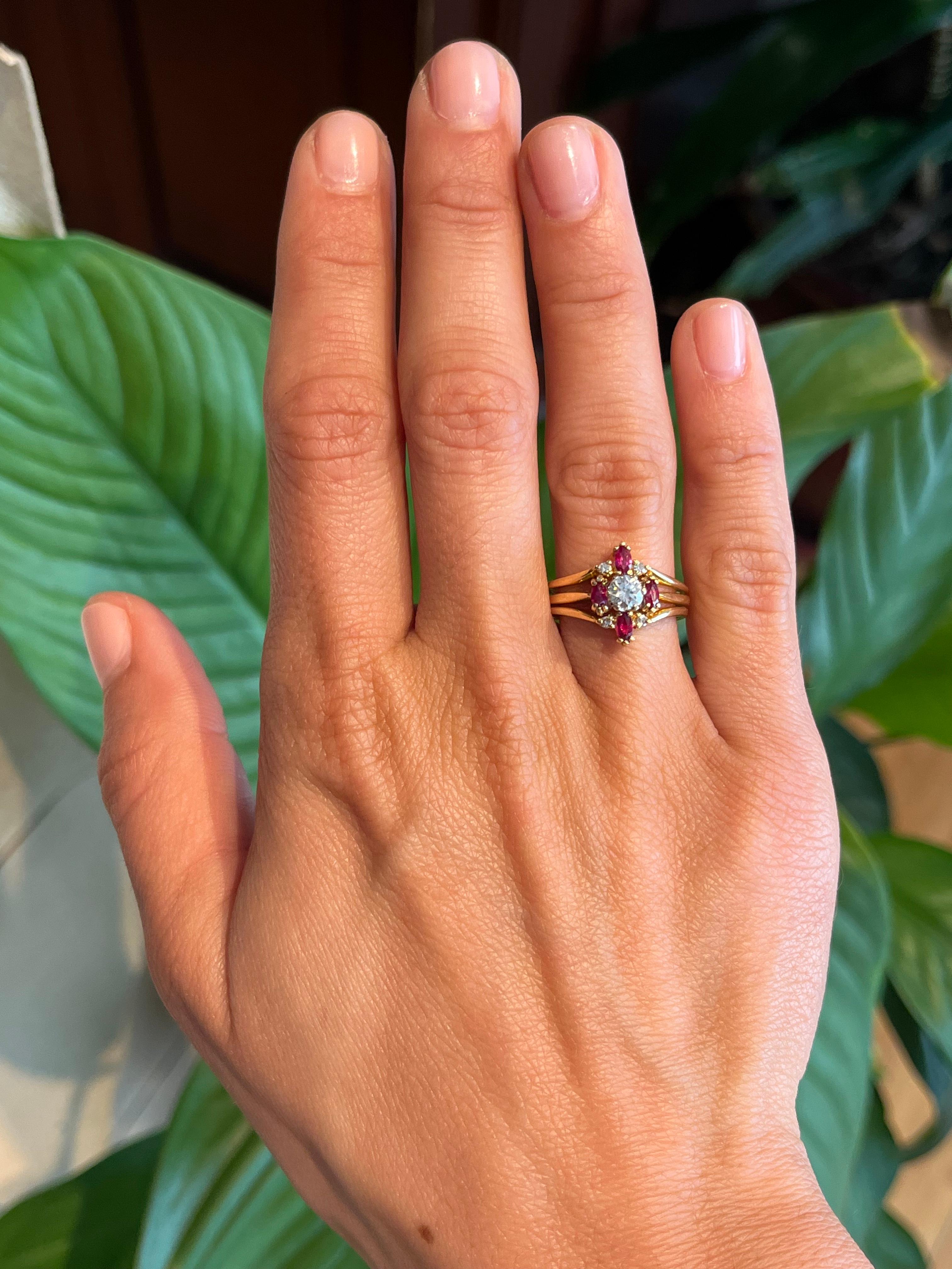 Dieser zweiteilige Verlobungsring im Vintage-Stil besteht aus einem runden Brillanten von 0,26 Karat, der von vier Rubinen im Marquise-Schliff und vier runden Diamanten im Einzelschliff ergänzt wird. Das verschlungene Design aus 14-karätigem
