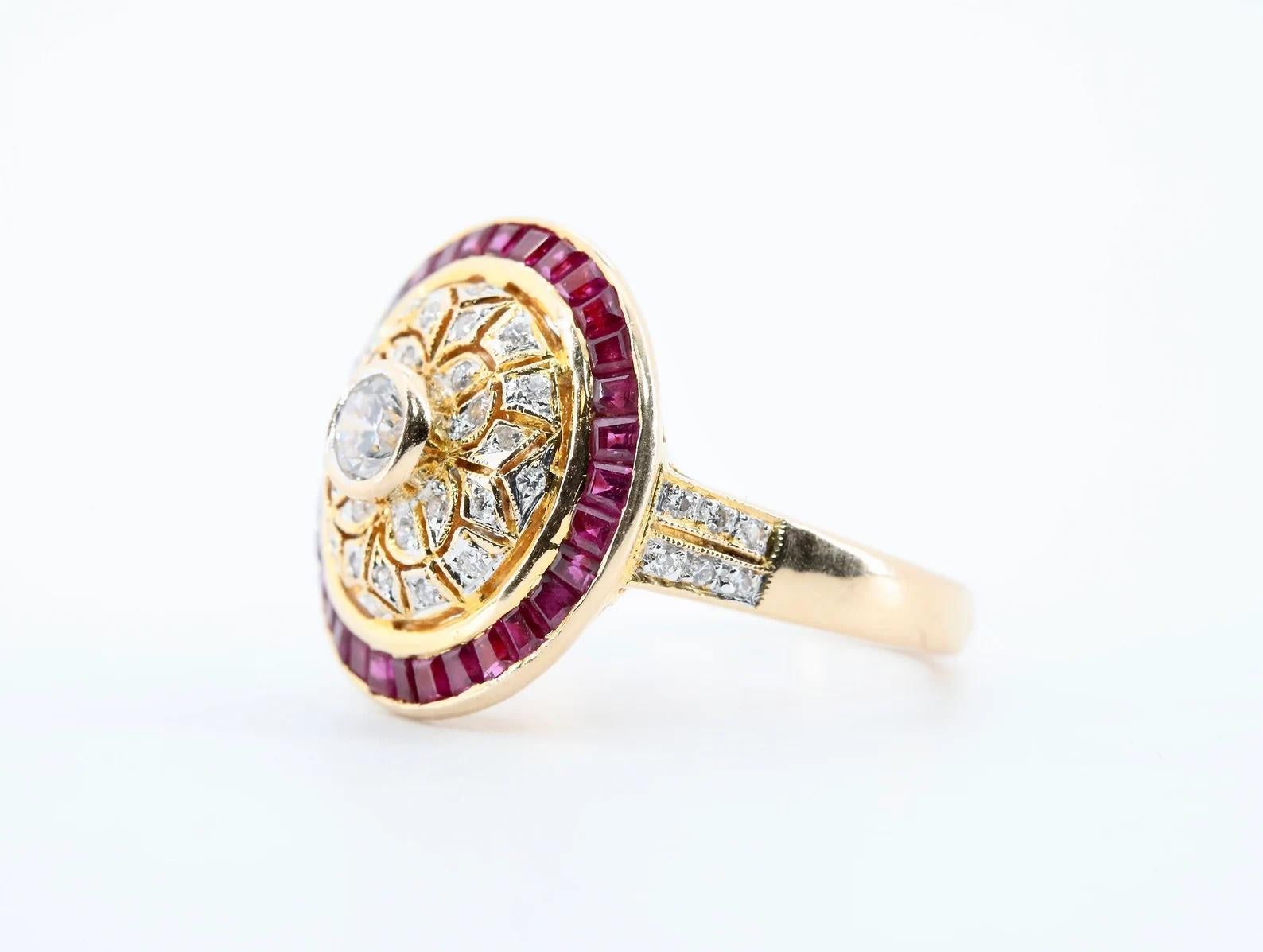 A beautiful ruby, and diamond cocktail ring in 18 karat gold. Centered by a 0.30 carat bezel set round brilliant cut diamond, and accented with 0.26 carats of pave set diamonds. The handmade mounting features filigree work throughout, complemented
