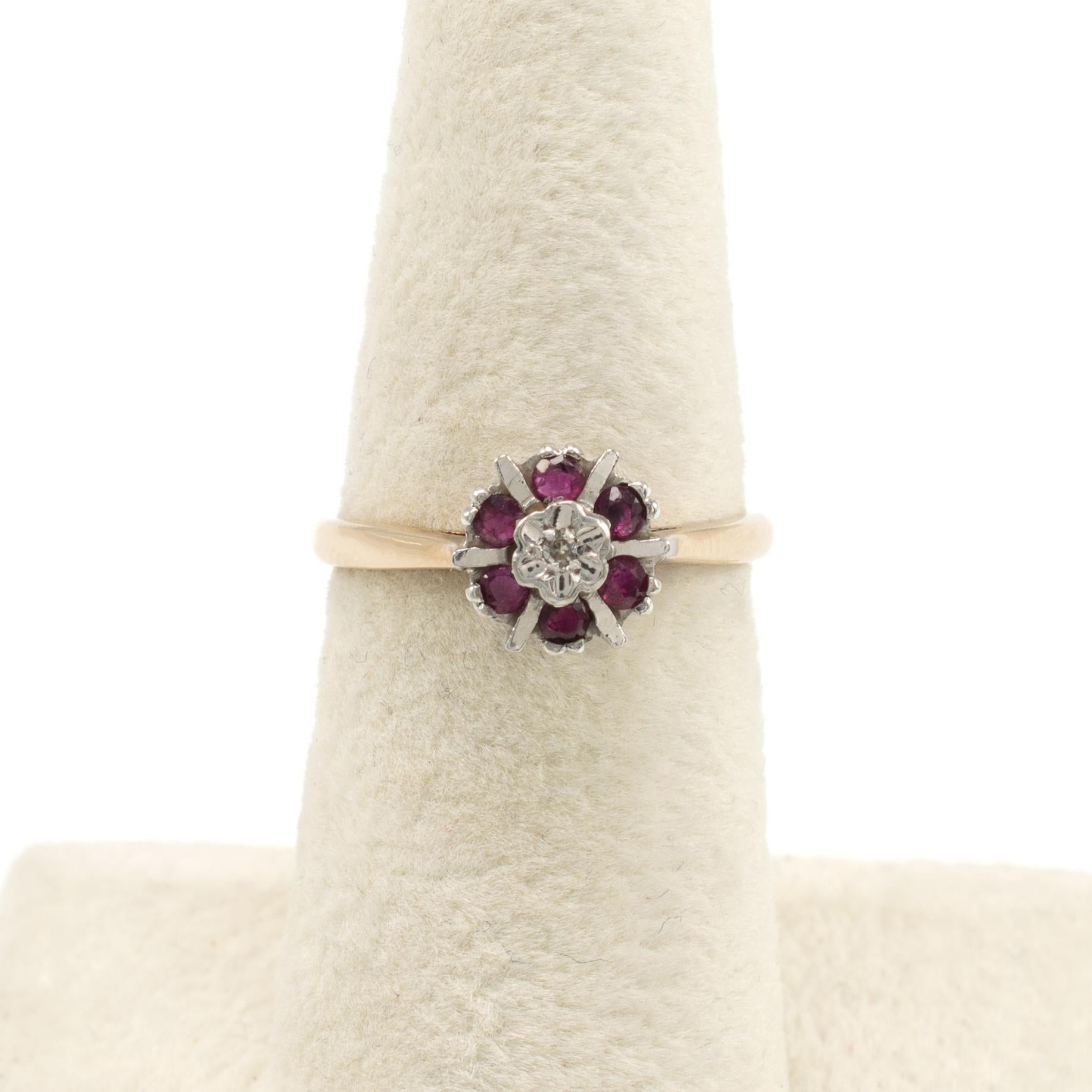 This pretty vintage ruby and diamond ring is beautifully made in yellow gold and features a tall platinum circular two tier mount set with center diamond and 6 complimenting rich rubies.

We have checked, cleaned and polished the ring and it comes