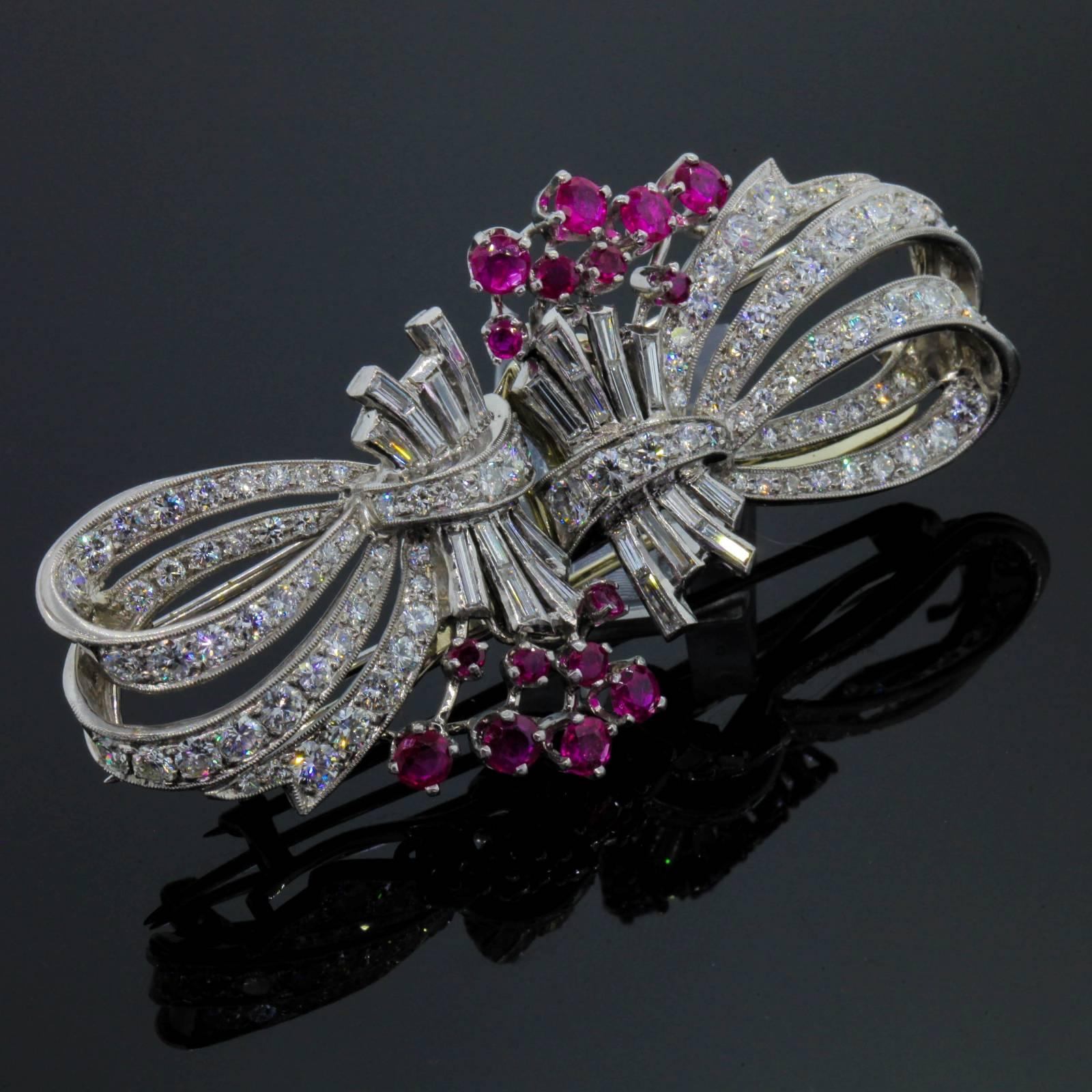 A coveted 1940s platinum brooch/clips.  The brooch is designed as flowing bows with two bouquets of Burma Ruby flowers.   Accenting the piece one hundred Transitional Cut Diamonds and twenty four Baguette Cut Diamonds, all diamonds weighing 6.50