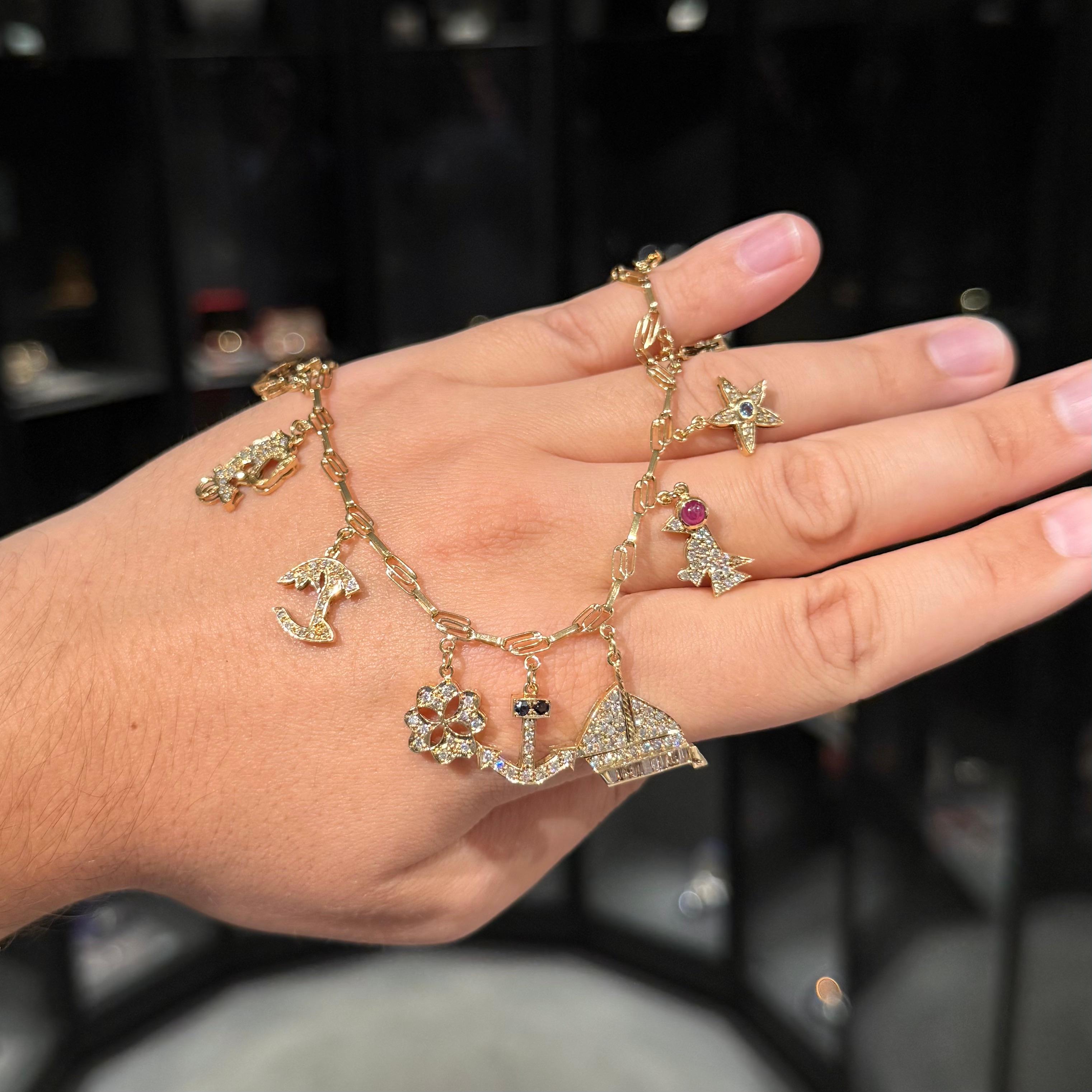 Bracelet à breloques vintage en or jaune serti de diamants et de pierres précieuses, probablement américain, années 1980. Un bracelet à breloques joyeux et nostalgique de la fin du XXe siècle en or jaune 14 carats, scintillant de diamants ronds de