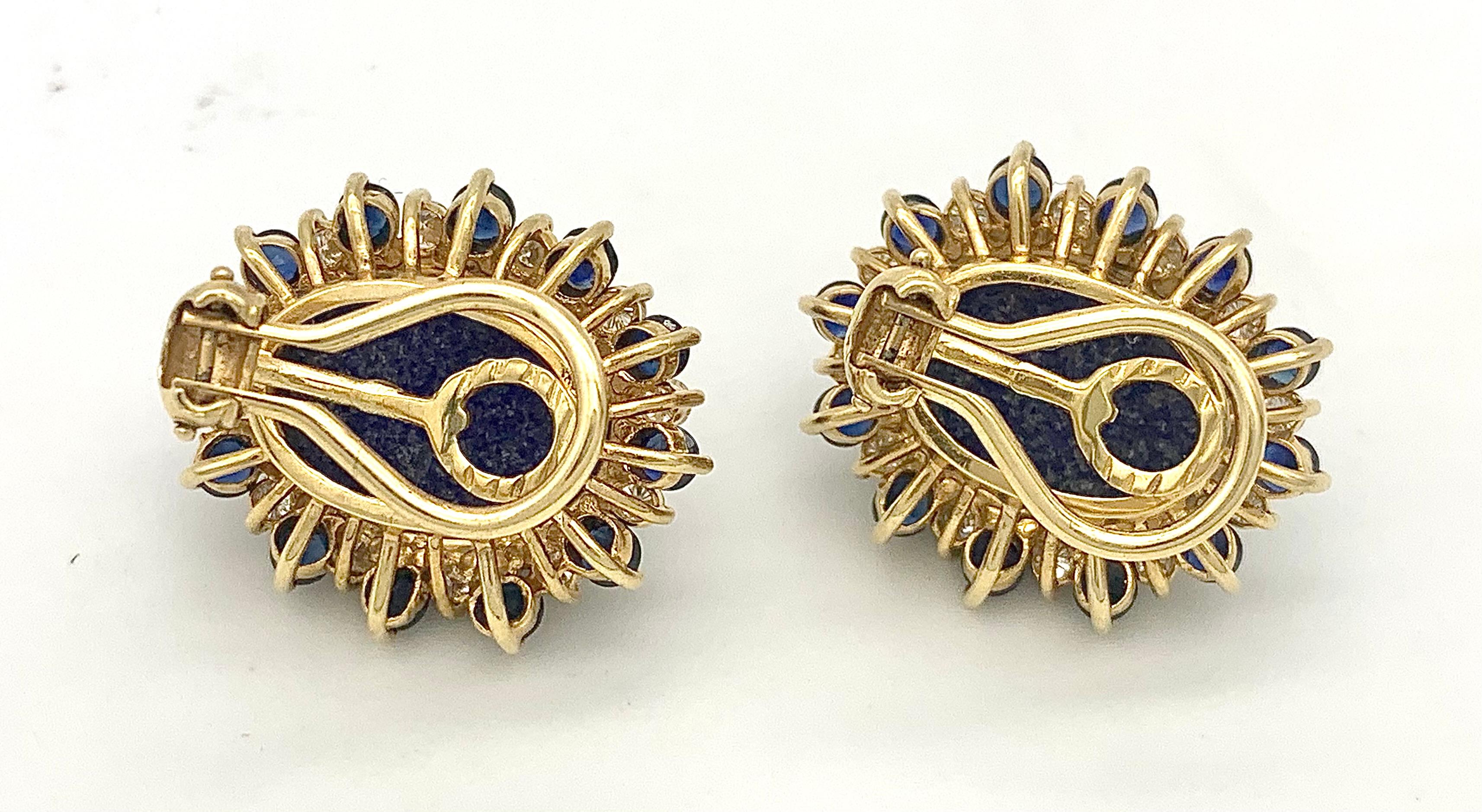 These colourful clip-on-earrings  are designed as stylized flowers with a large lapis lazuli cabochon in the centre surrounded by gem set flower petals. Each ear clip is surrounded by twelve round cut sapphires alternating with 12 round cut