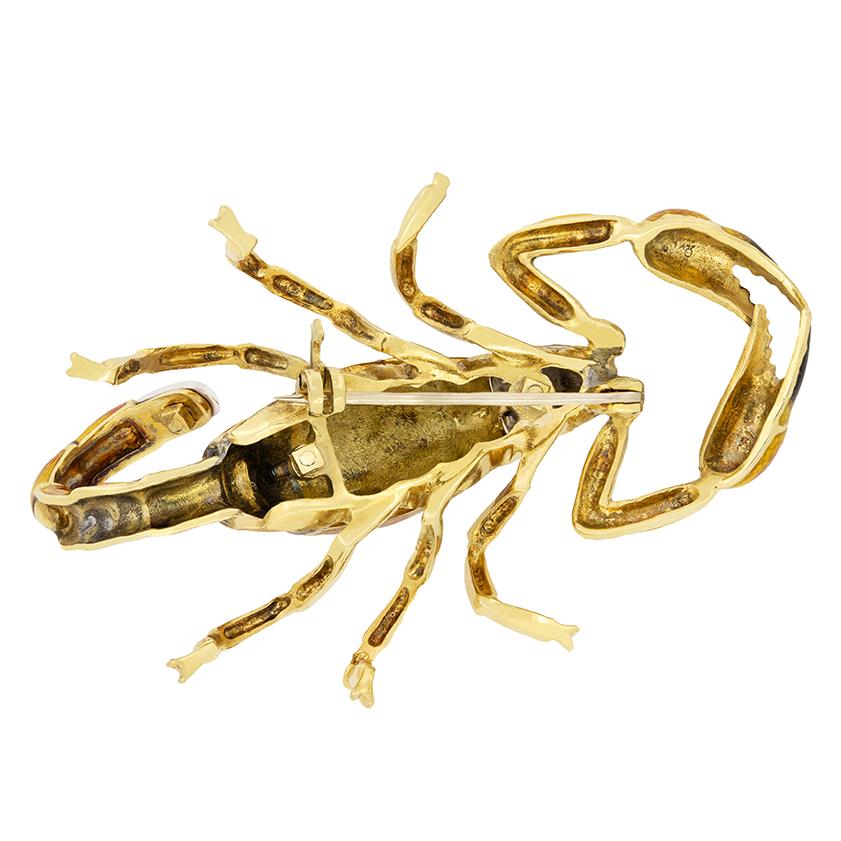Created in 18 carat yellow gold, in the likeness of a scorpion, this vintage brooch is a truly unique piece. Enamelling work of red yellow and black creates the detailing, bringing the scorpion to life. Across it’s back and on the tip of the tail a