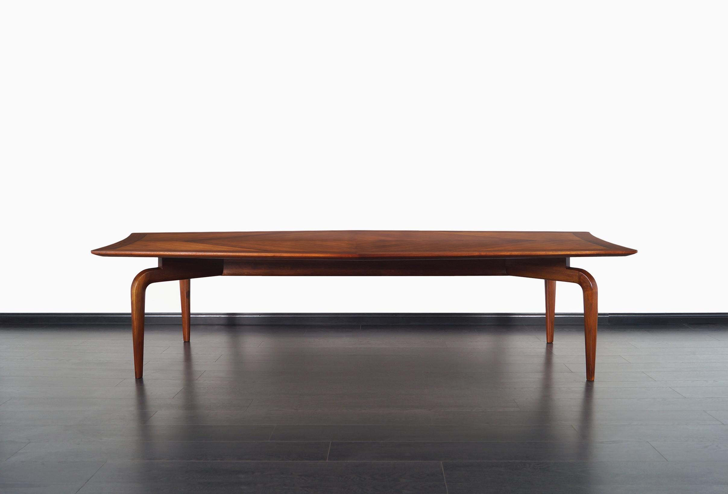 Monumental vintage walnut table designed by Maurice Bailey for Monteverdi Young in the United States, circa 1960s. This beautiful piece of furniture has a daring design, in the upper part, we have a completely smooth top in a sculpted diamond shape