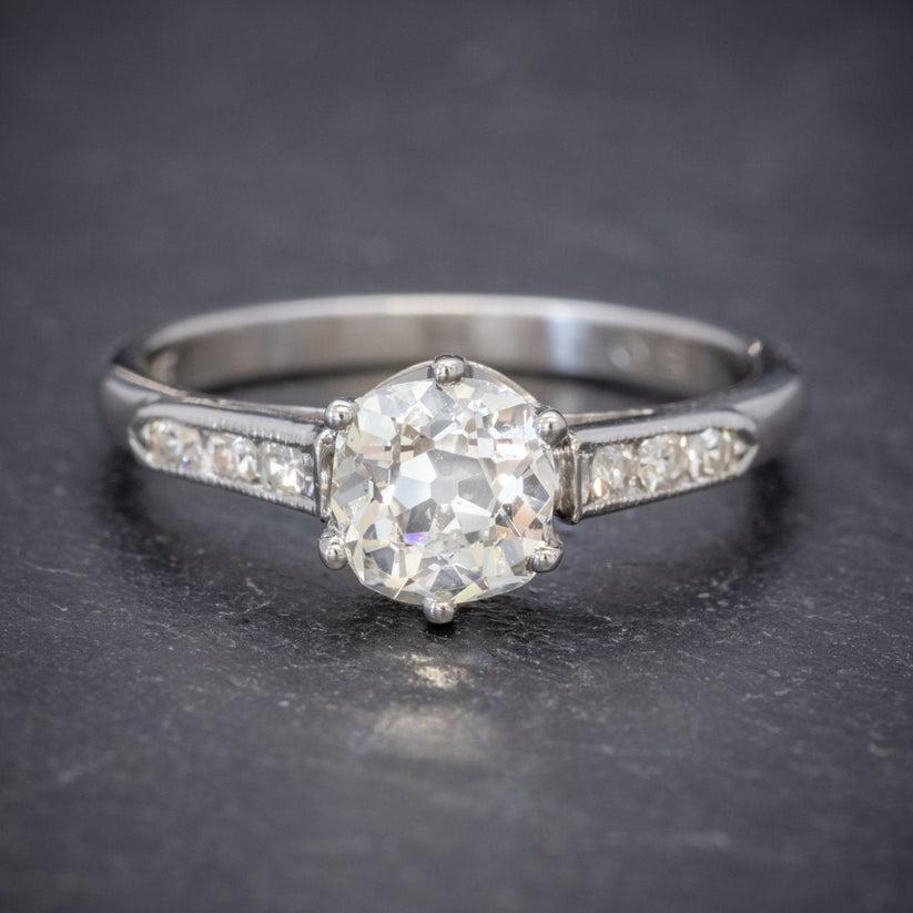 A stunning 1960s solitaire ring crowned with a beautiful old cushion cut diamond which has been weighed at 1.25 carats. It has excellent VS2 clarity – G colour and sparkles beautifully in the light.

The solitaire is mounted in a platinum gallery