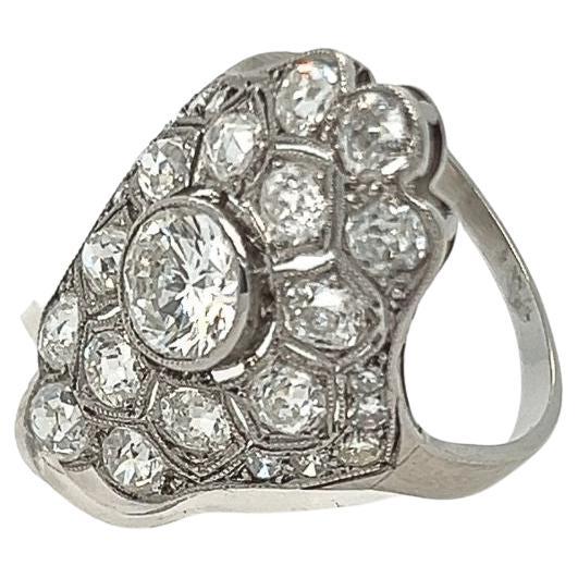 This vintage diamond star ring features an elegant platinum setting, highlighting the brilliance of its central diamond surrounded by a dazzling starburst of additional diamonds. The center stone is a round-cut diamond, meticulously placed to catch