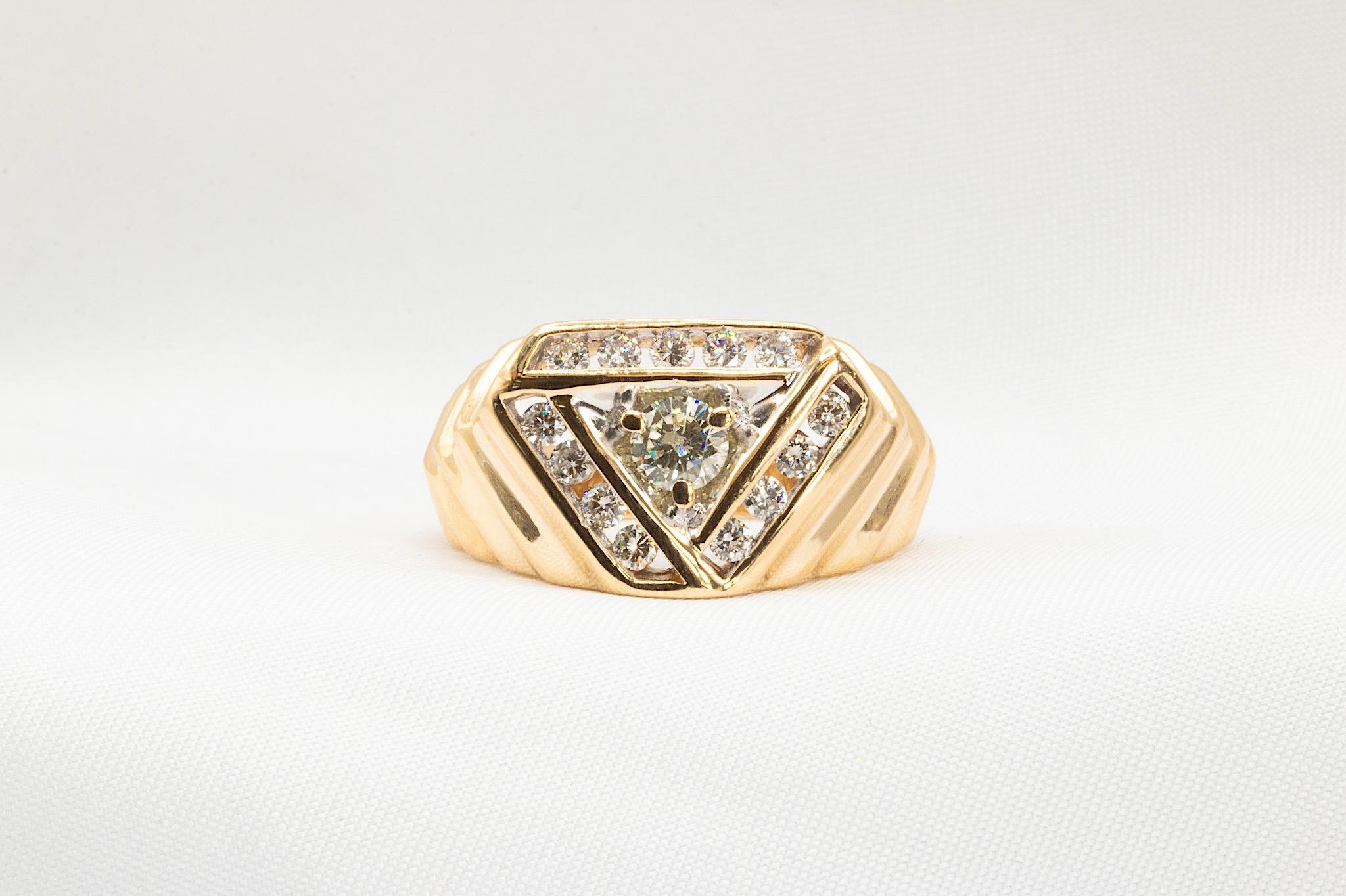 Cette bague de style chevalière est composée de 13 diamants ronds de taille brillant, totalisant environ 0,45 ct. ensemble, de couleur H-I et de pureté VS2, et d'un diamant rond de taille brillant au centre pesant environ 0,30 ct. et de couleur H-I