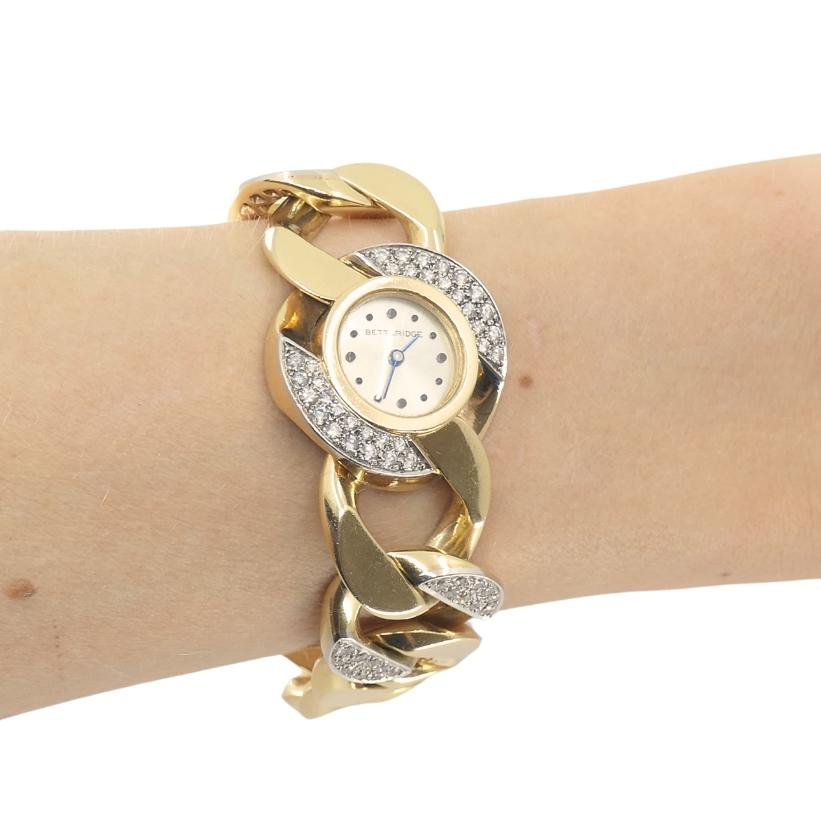 Reloj vintage de diamantes de Betteridge, con brazalete de cadena curblink; fabricado en oro de 14 quilates.
La esfera del reloj parece primero una pieza de joyería y luego un reloj. El fondo de la esfera tiene un bonito brillo nacarado. Las finas