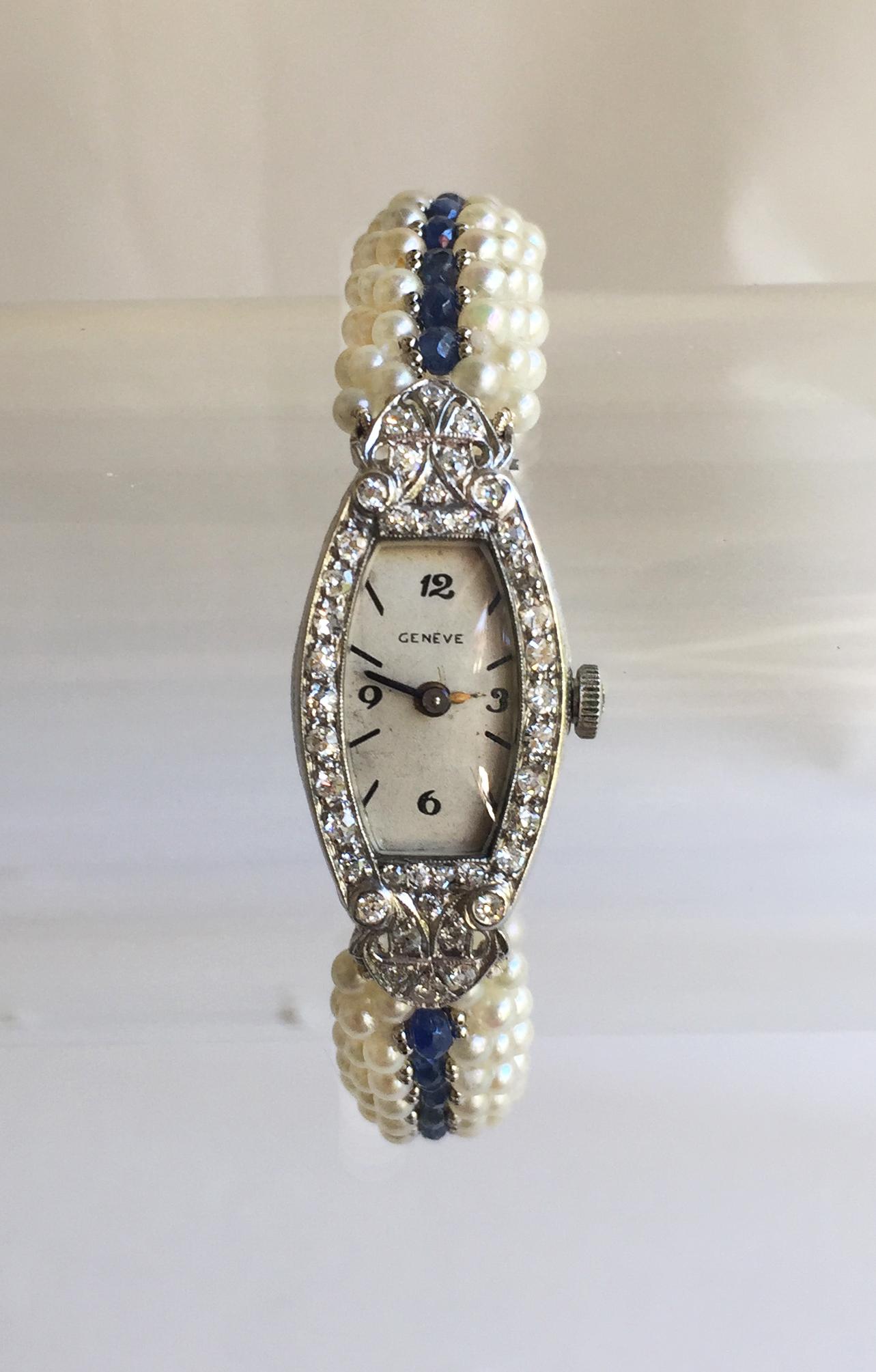 This vintage diamond watch with a cultured Japanese white pearl and blue sapphire band and 14k white gold clasp is a fully functional watch, as well as  gorgeous. The band is composed of woven glowing white pearls, down the middle are faceted