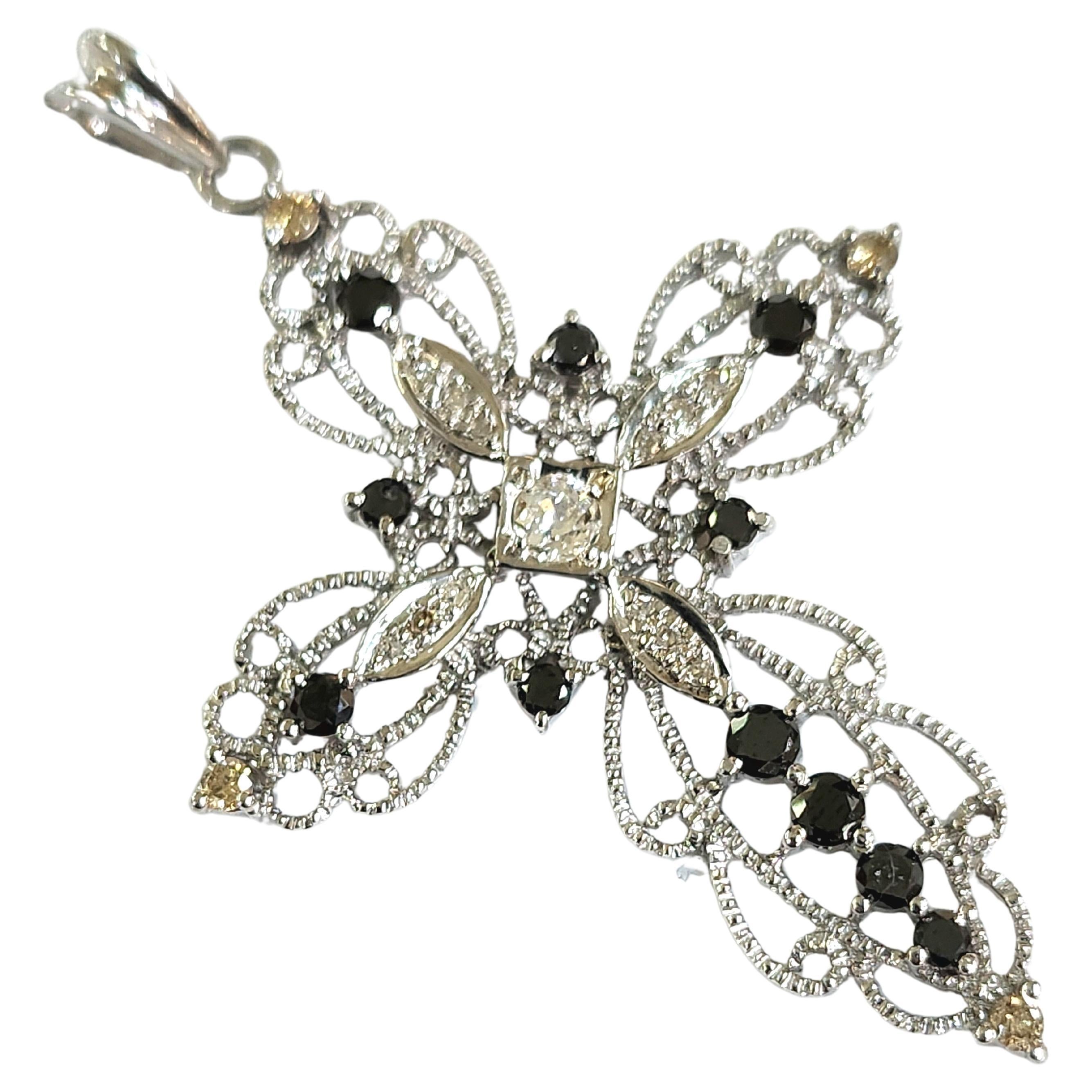 Vintage 1950s 18k white gold cross pendant in open work style centered with old mine cut diamond flanked with brilliant cut black diamonds and white diamonds total diamond weight 0.70 carats and total gold weight 6.50 grams hall marked 18k and 750
