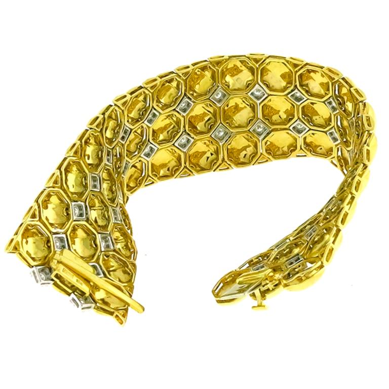 This amazing 18k yellow and white gold bracelet is set with sparkling round cut diamonds that weigh approximately 4.35ct. graded H color with VS2-SI1 clarity.
The bracelet measures 31mm in width and 7 1/2 inches in length. It weighs 95.7 grams and