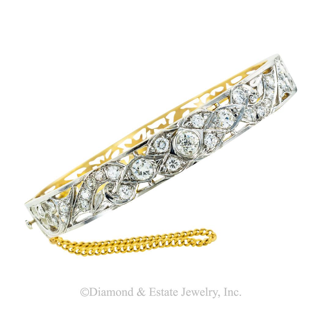 Vintage diamond and gold hinged bangle bracelet circa 1930. 

SPECIFICATIONS:

DIAMONDS:  twenty-five round diamonds totaling approximately 1.75 carats, approximately H-K color, SI-I clarity.

METAL:  14-karat gold with pierced motifs on both halves