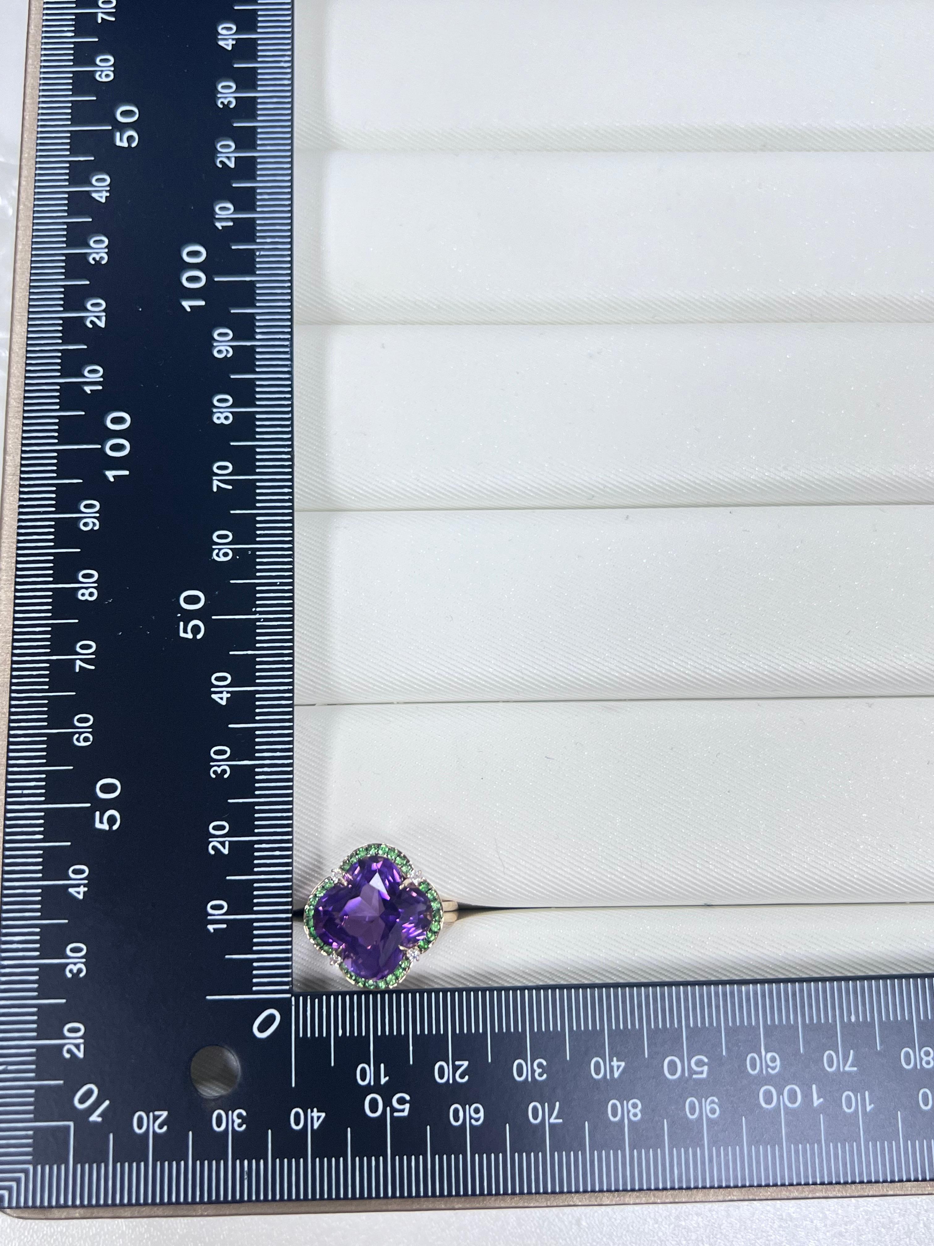 Este exquisito anillo vintage de oro macizo de 14 quilates para mujer exhibe una impresionante Amatista de 10,6 quilates, envuelta en un elegante halo de Esmeraldas verdes vibrantes de 0,31 quilates, con delicados acentos de Diamantes de 0,06
