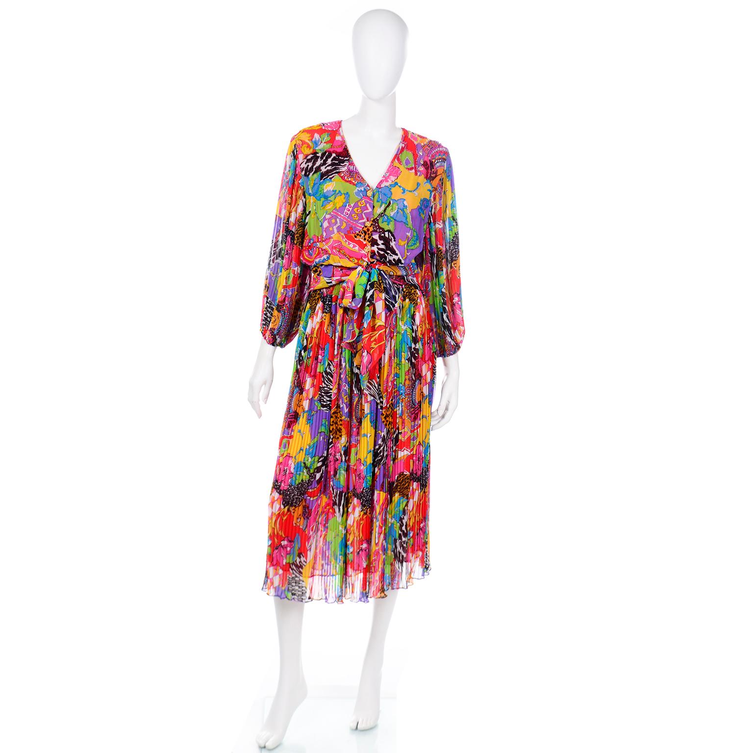This is a fun vintage Diane Freis 2 piece dress in a bold multi patterned print. The easy to wear top has pleated sleeves with elastic cuffs and a fitted waist. with a wide attached sash tie and ruched lower sides. There are pearls, sequins and