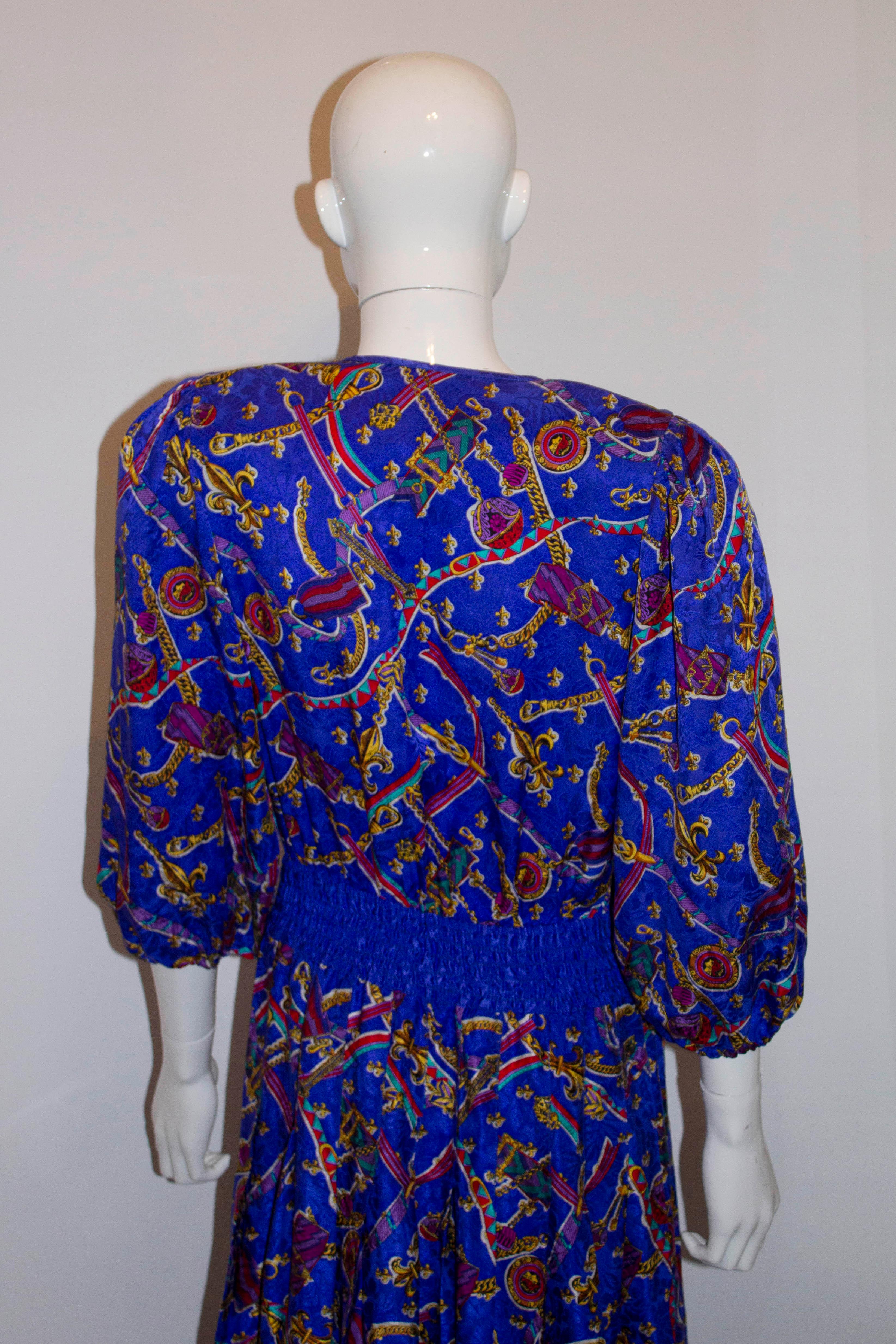 A pretty vintage silk dress by Diane Freis, petite range. The dress has a blue background with a chain print. It has an elasticated waist with a button opening at the front. There are pleats that start 5''below waist leval producing a flattering 