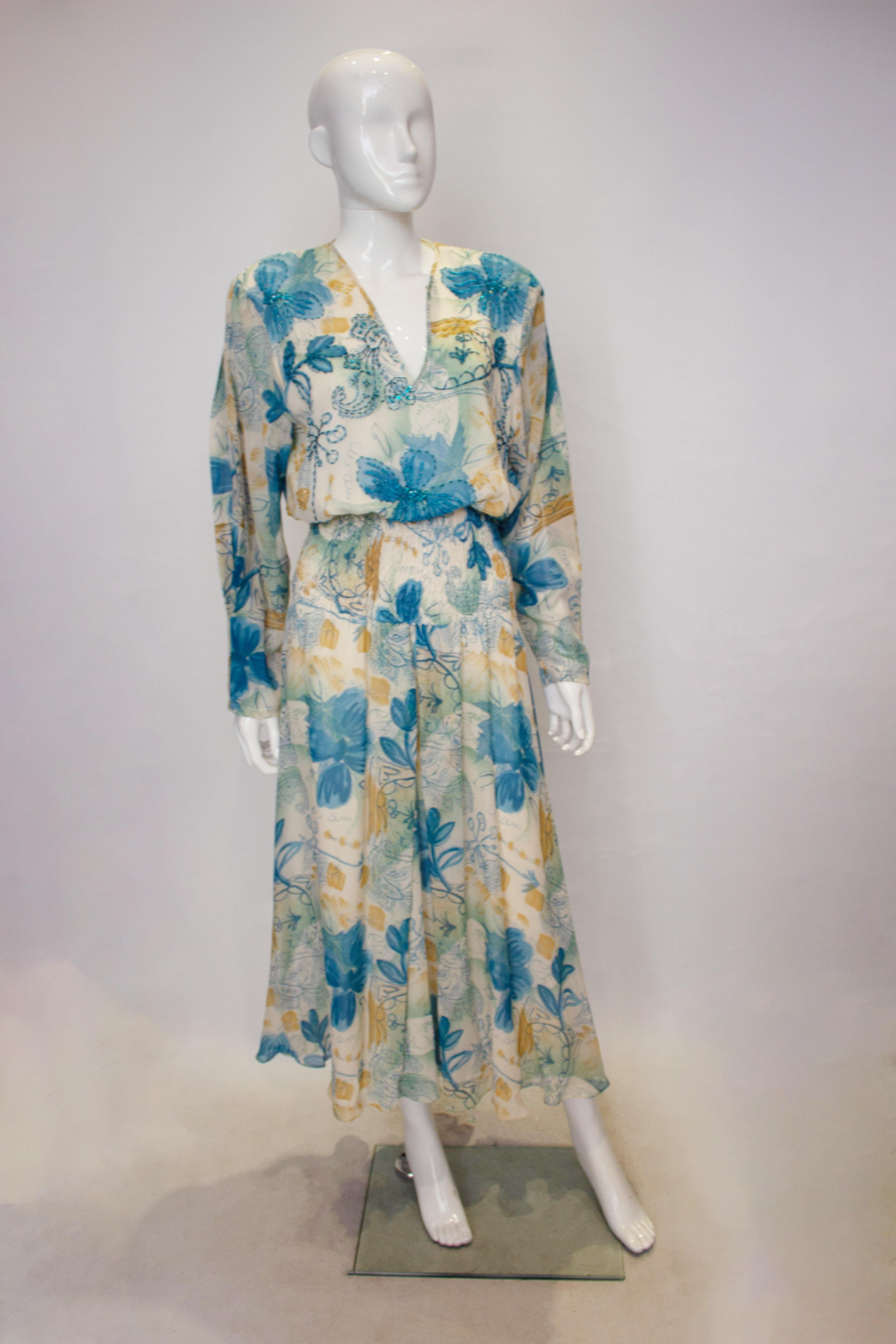 A head turning vintage silk dress by  Diane Freis. Both the outer fabric and lining are silk.  The dress has an ivory background, with a pretty blue and brown print and bead detail. It has an elasticated waist and will fit a waist 24'' -31'' and has