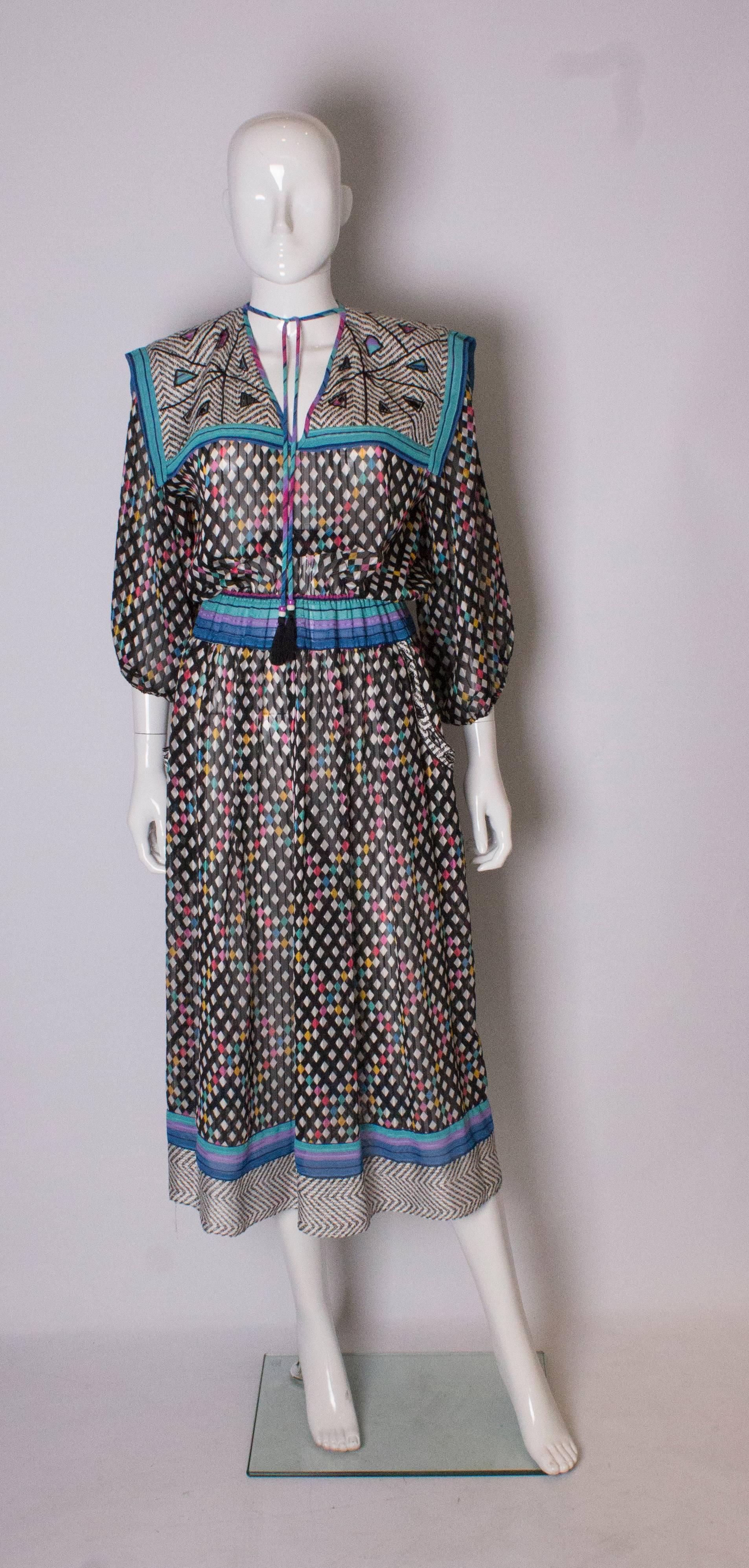An easy to wear vintage dress by Diane Fres. The dress has elbow length sleeves with elasticated cuffs, a v neck with a large sailor collar with cut out detail. There are two pockets at hip leval, and the dress has an elasticated waist that