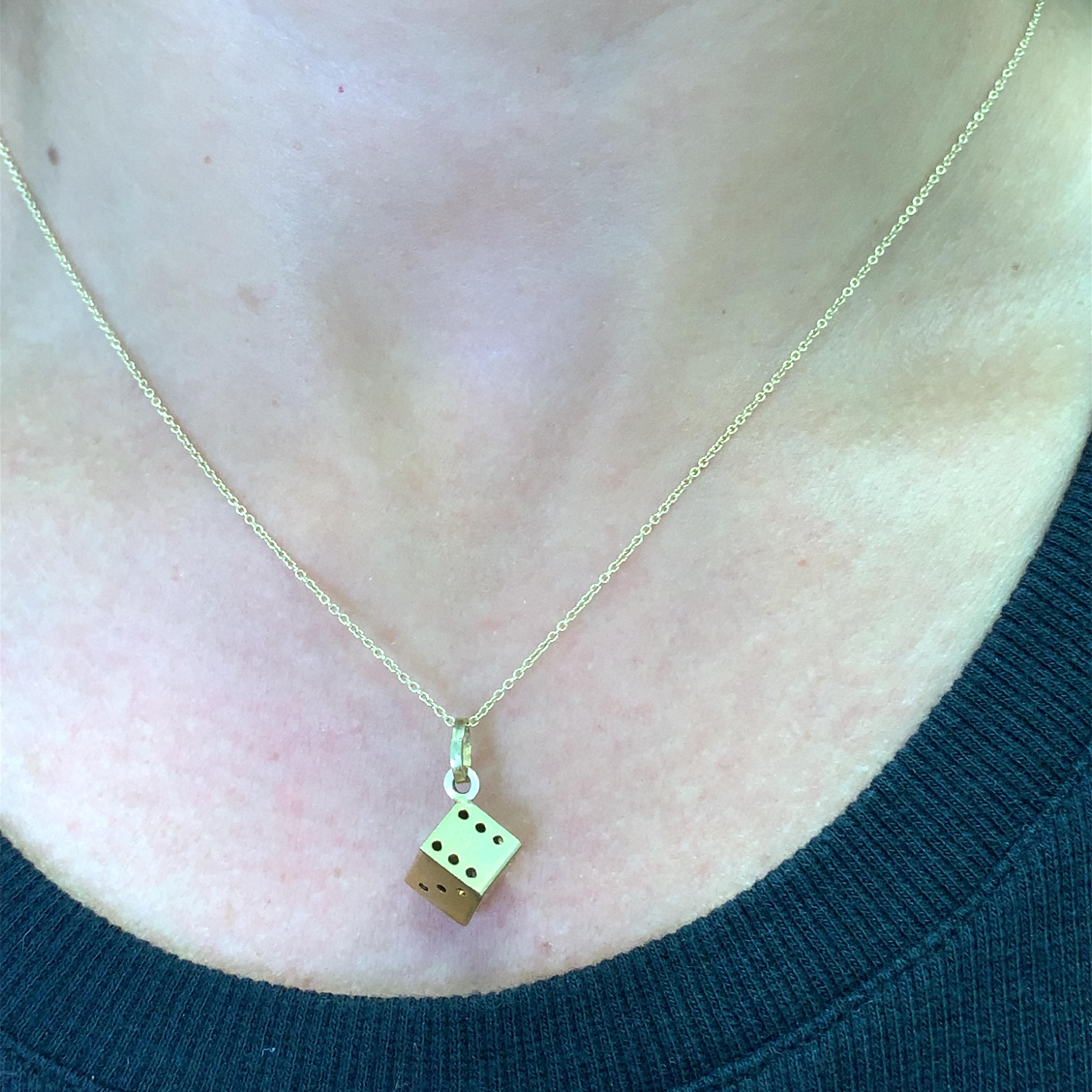 Erhöhen Sie Ihren Stil mit dieser skurrilen Halskette mit Charme. Dieses verspielte Stück aus warmem Gelbgold ist mit einem einzigartigen Würfelanhänger versehen. Perfekt, um jedem Outfit einen Hauch von Spaß und Persönlichkeit zu verleihen. Ein