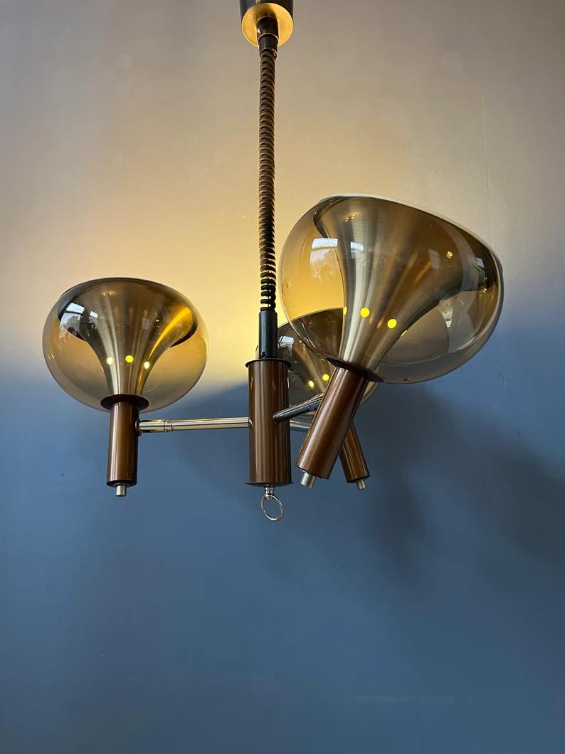 Rare vintage Dijkstra space age chandelier with three shades. The shades have an outer acrylic glass part and an inner aluminium part. Together the parts create a magnificent light. The lamp requires three E27/26 (standard) lightbulbs.

Additional