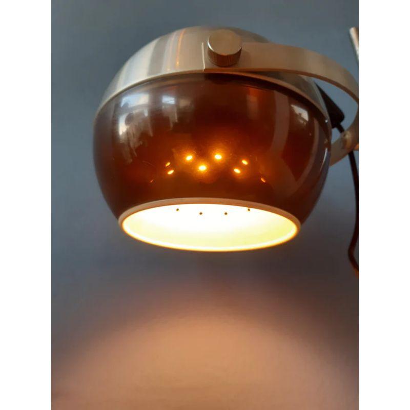 Very rare Dijkstra Holland space age table lamp. The space age shade consist of a synthetic, bronze/brown outer shade and an aluminium inner shade. The shade can be positioned in any direction desirable and can be easily moved up and down the base.
