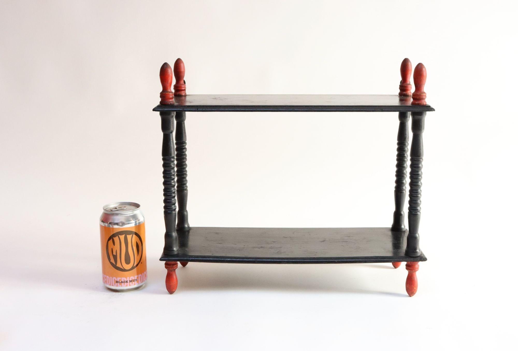 Vintage Diminutive Schwarz lackiert Tisch oder Wandregal mit geschnitzten roten Endstücken (Metall) im Angebot