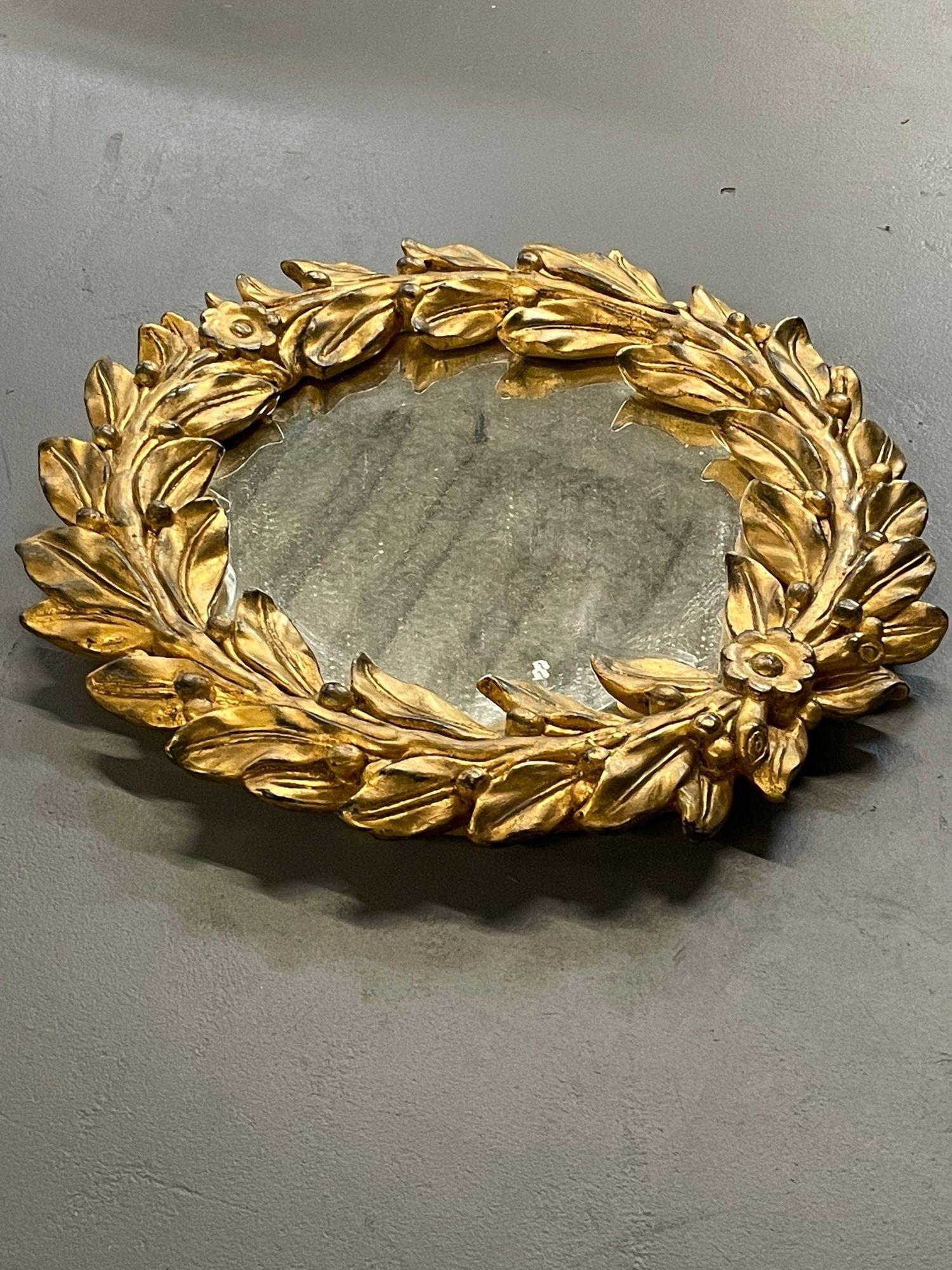 Vintage Diminutif miroir mural sculpté en bois doré de designer italien, détail de feuilles. Le style Mario Buatta 
 
Chic petit miroir de style italien avec un cadre en bois sculpté et doré - par un designer italien inconnu. Forme similaire à