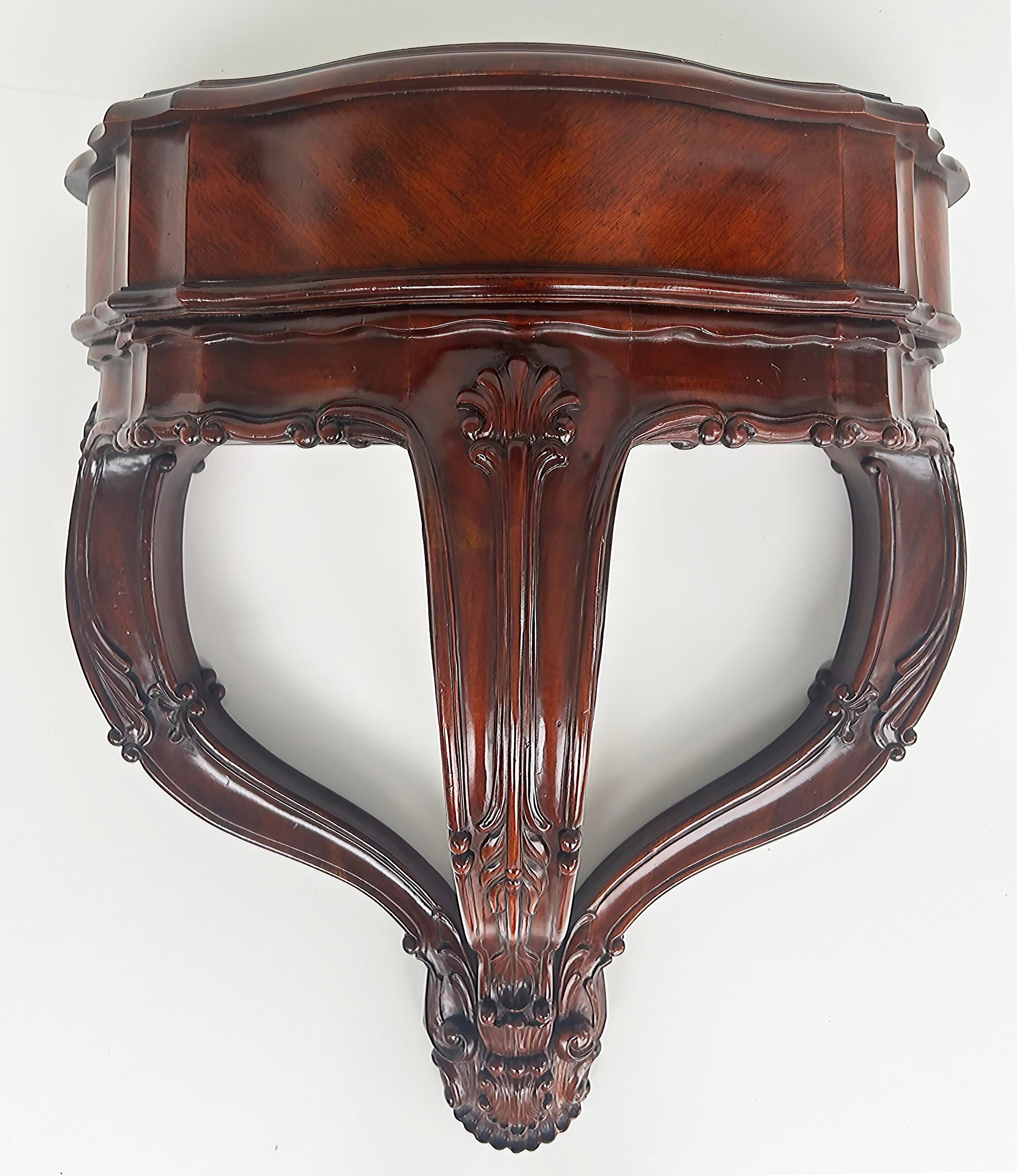 Vintage Diminutive Wall-mounted Shell Carved Console Table in Mahogany

Offered for sale is a wall-mounted diminutive beautifully carved console table with a decorative shell motif. The console has brackets on the back to secure to the wall and the