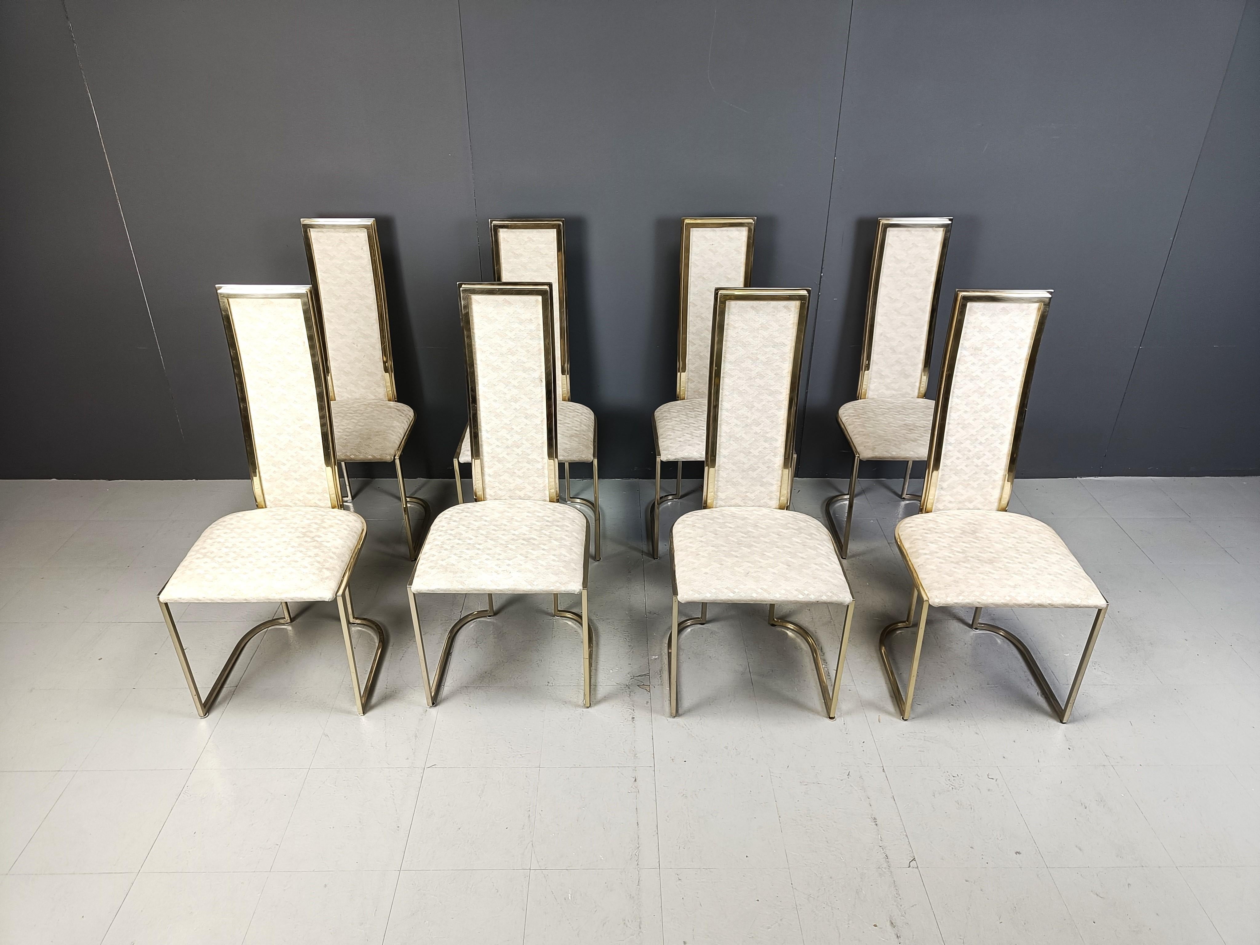 Set of eight elegant high back dining room chairs manufactured by Belgochrom.

The chairs consist of fine brass frames upholstered with the original fabric which has a beige checquered motive.

They look good in modern day interiors.

Belgochrom