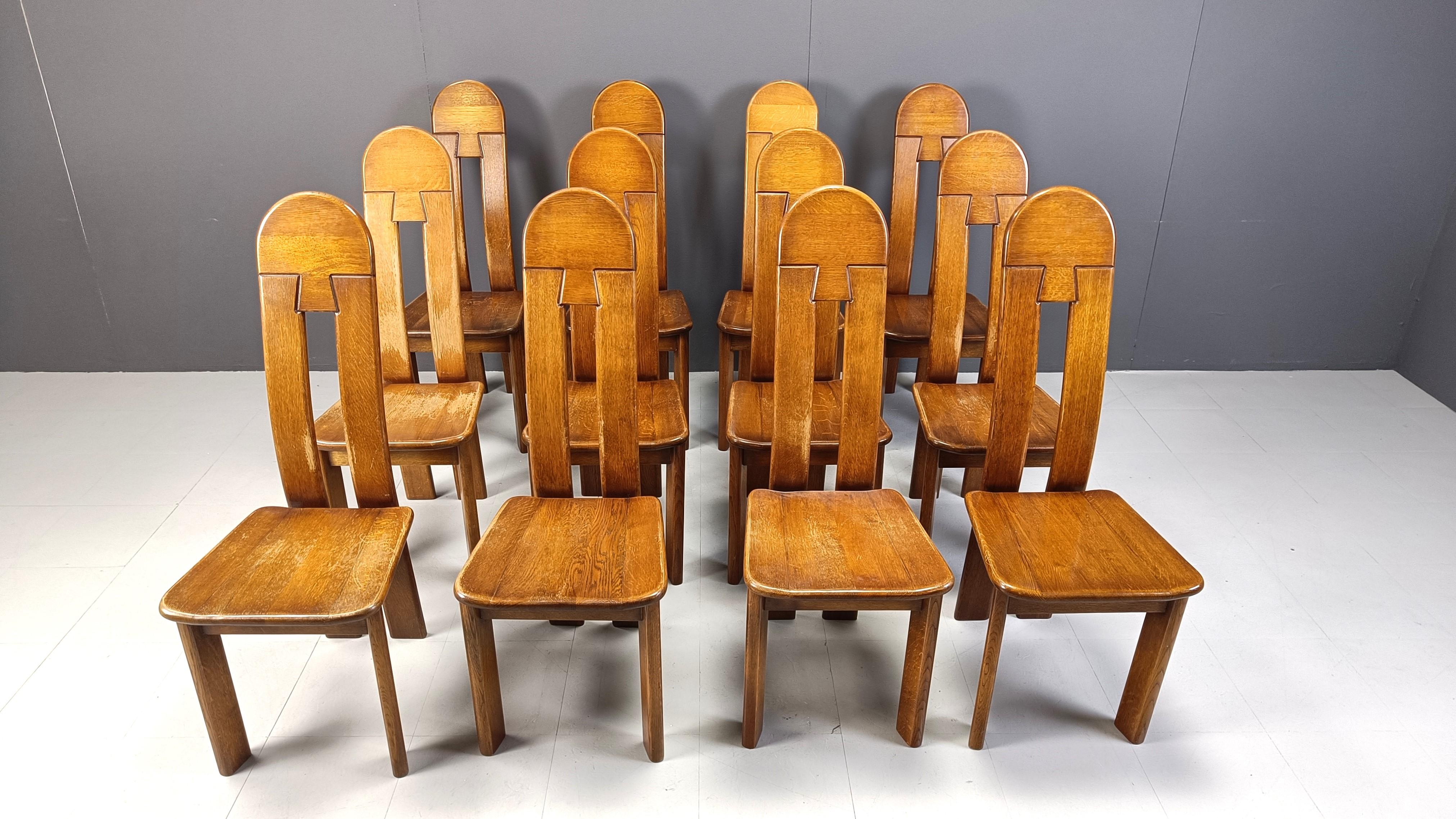 Set of 12 sturdy and handcrafted dining chairs produced by Depuydt Kunstmeubelen in Belgium.

The chairs are made from solid oak.

Beautiful split backs with interlocking wooden pieces.

These chairs and table will last for ages.

Good
