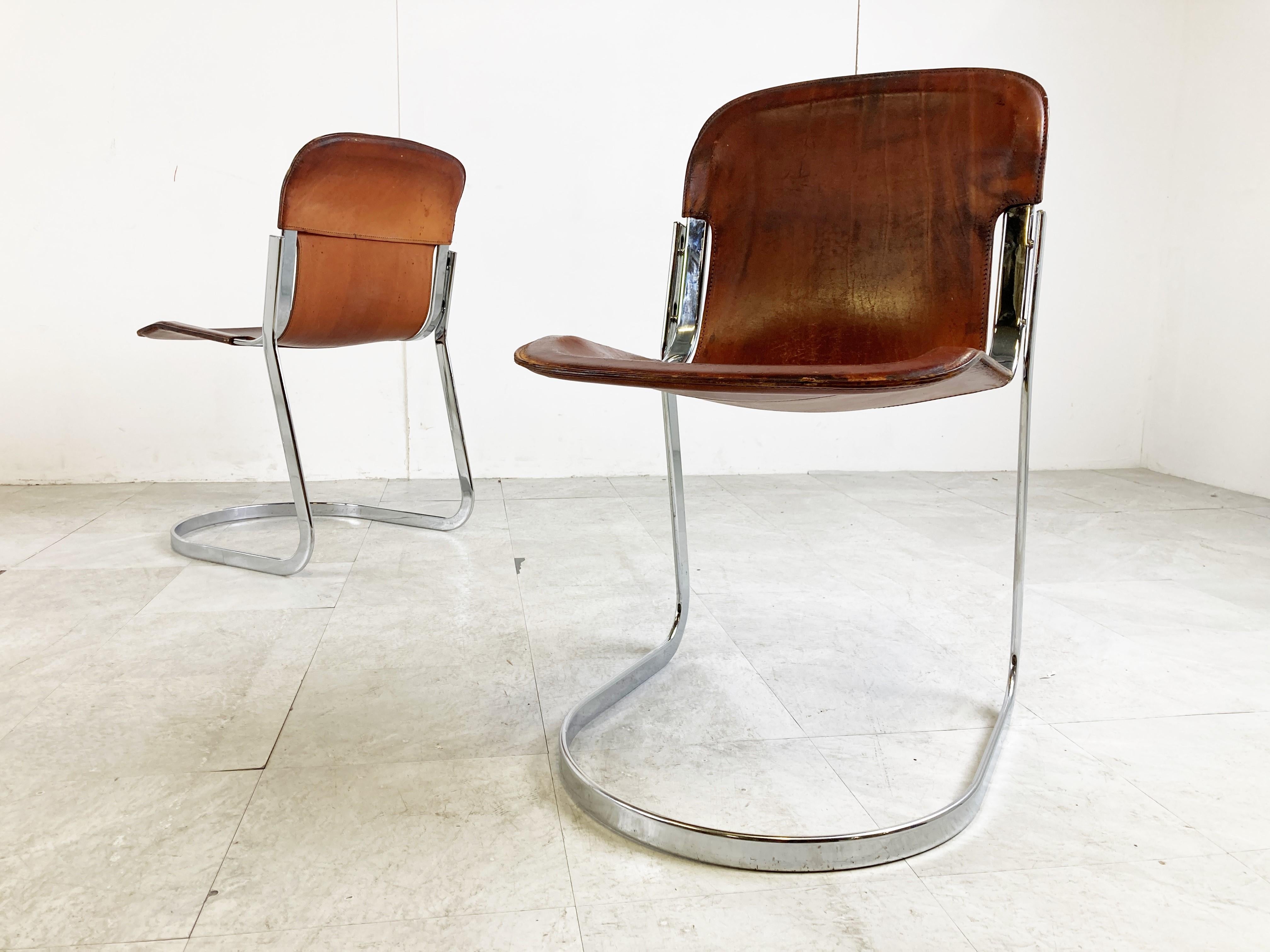 Set of 4 dining chairs designed by Willy Rizzo for Cidue (model C2).

The chairs have a beautifully shaped chrome frame and come with the original black leather seats.

The chairs are stackable.

Good vintage condition

The chairs still look