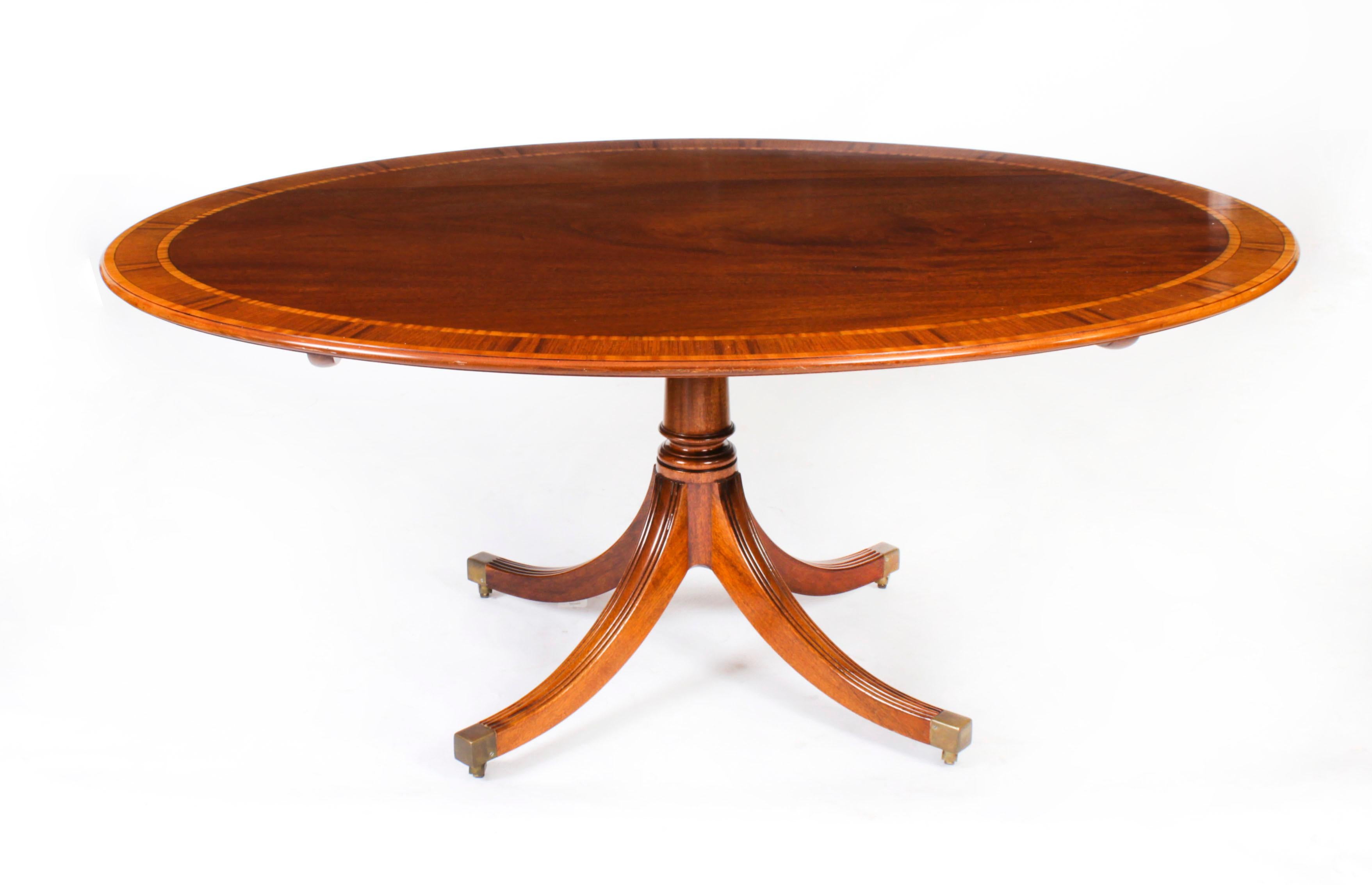 This is a beautiful Regency Revival flame mahogany and Satinwood banded oval dining table dating from Circa 1980, made by the Master Cabinet maker William Tillman and bearing his label on the underside, with a matching set of six swagback Regency