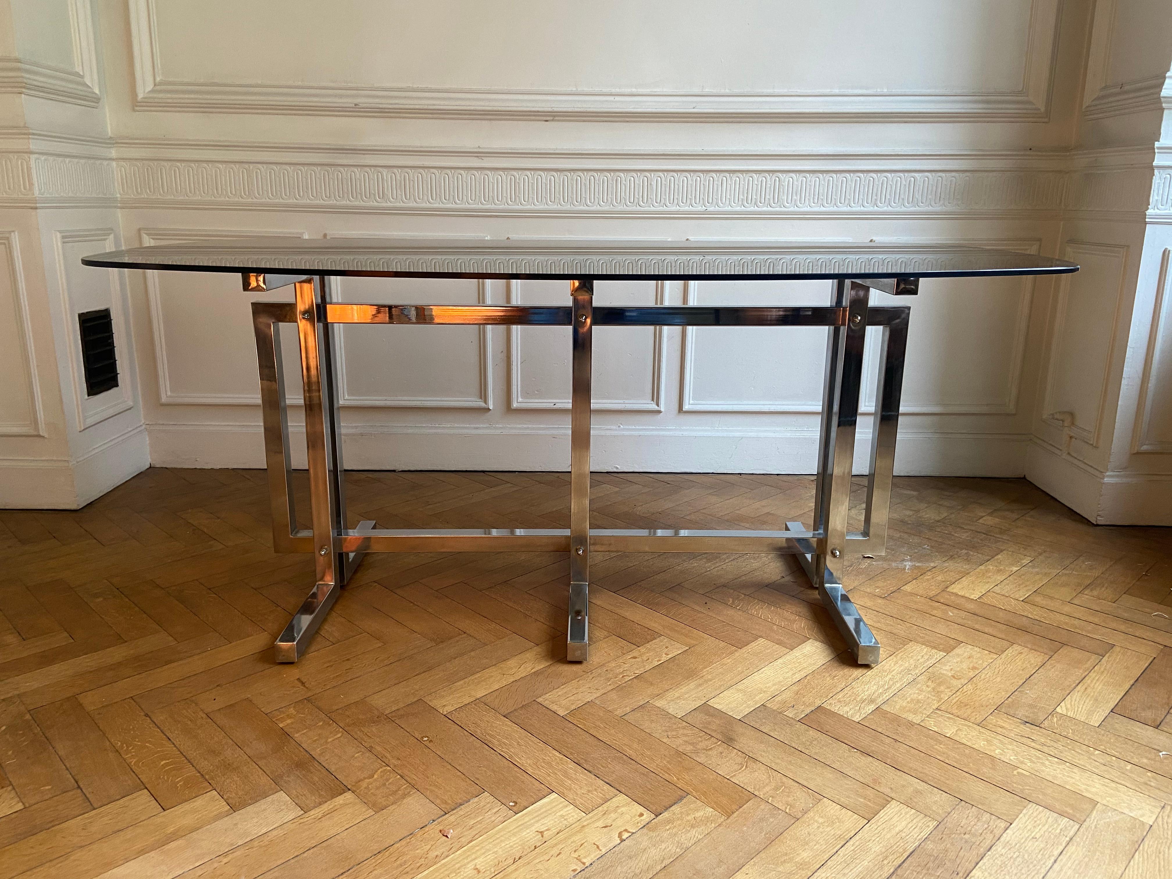 Vintage dining table. Graphic feet in chrome metal. Smoked glass top. State of use consistent with age