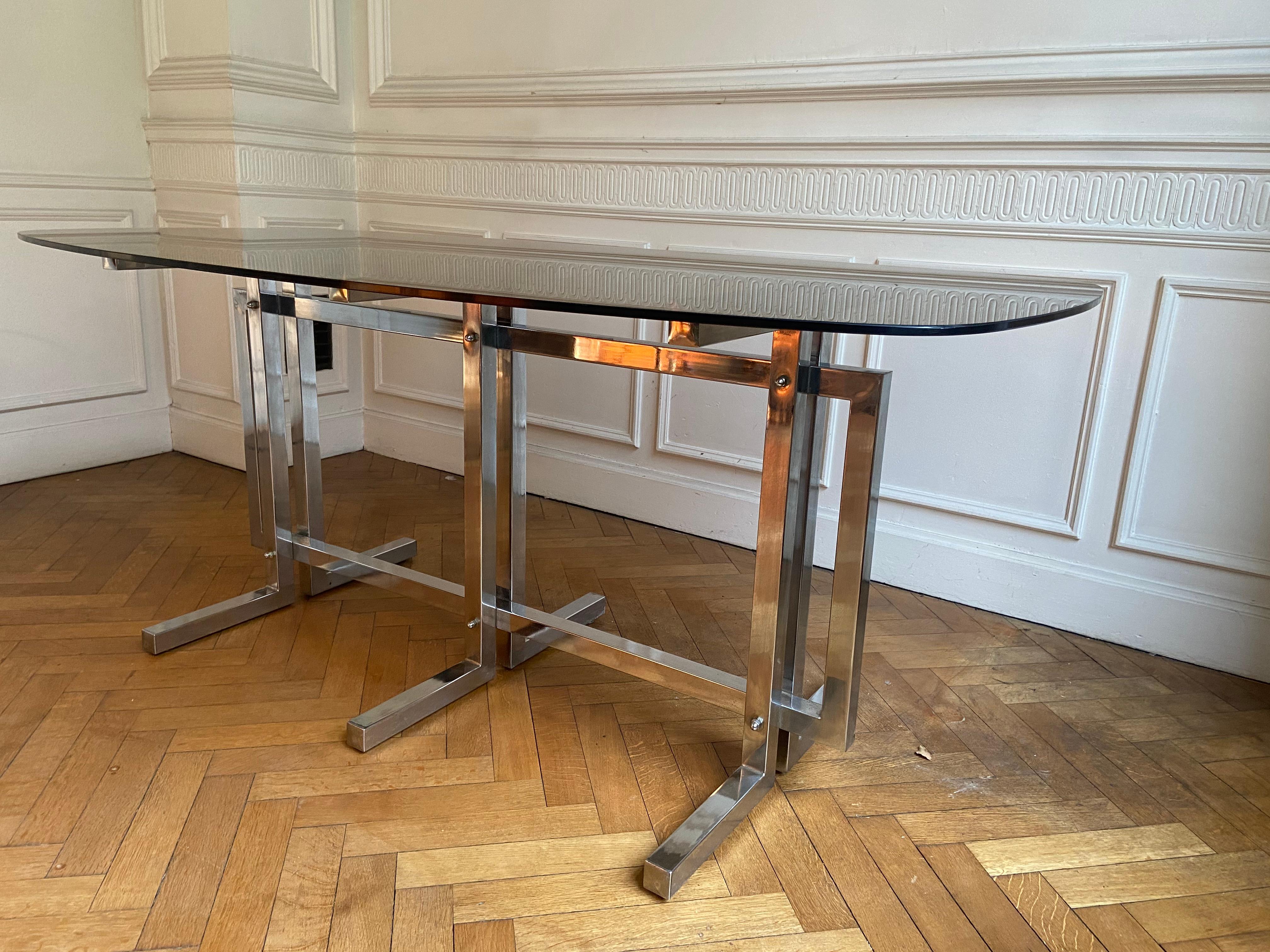 Glass Vintage dining table. Graphic feet in chrome metal. Smoked glass top.