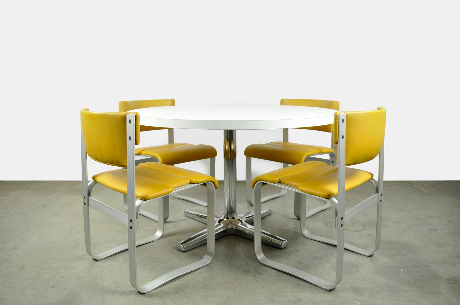 combined dining table set by Asko / Ilmari Lappalainen and Pastoe from the 60s and 70s. The “Pulkka” chairs are made of anodized aluminum with yellow leatherette upholstery and the round table has a white melamine top and a chromed base. 
dimensions