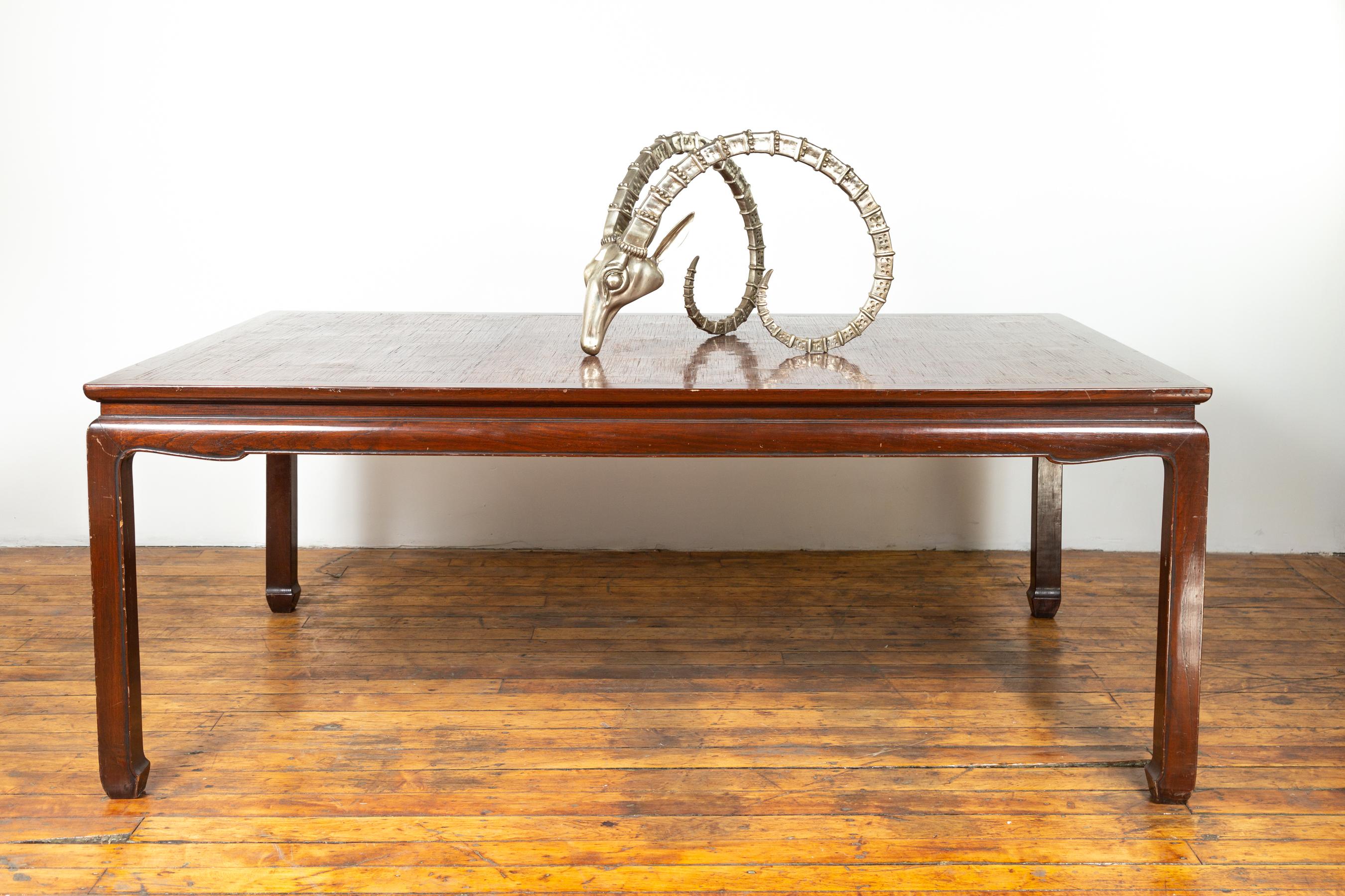 A vintage Thai dining table from the mid-20th century, with open mat top inlay and horsehoof legs. Born in Thailand during the mid-century period, this elegant dining table features a rectangular open mat inlaid waisted top sitting above an arched