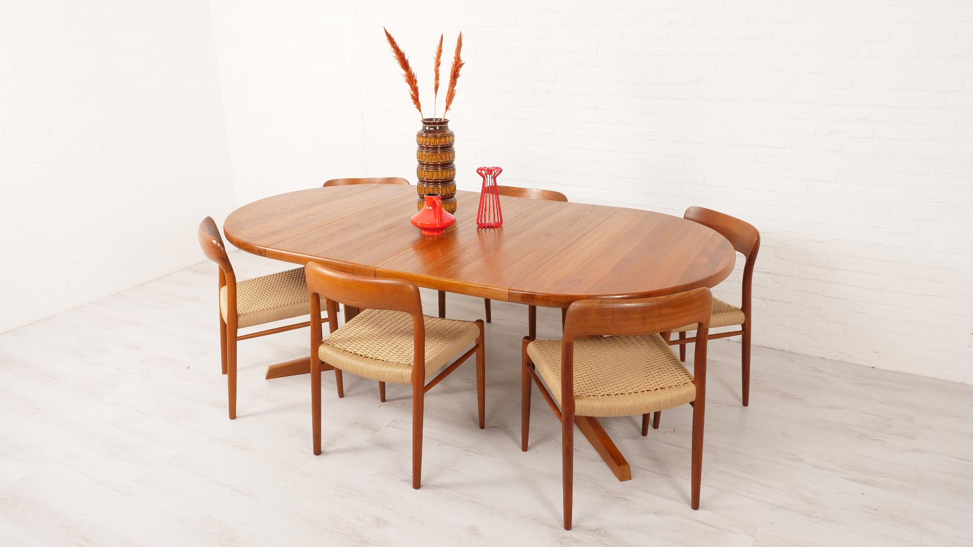 This beautiful, large round vintage dining table was designed by Niels Otto Møller in Denmark. The table is made of solid teak wood. A true example of Danish top quality! The round wooden dining table can be extended into an oval dining table with 2