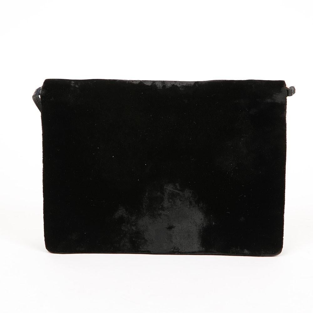A real jewel for connoisseurs! This Dior flap bag is made of black velvet and adorned with the iconic symbol of 