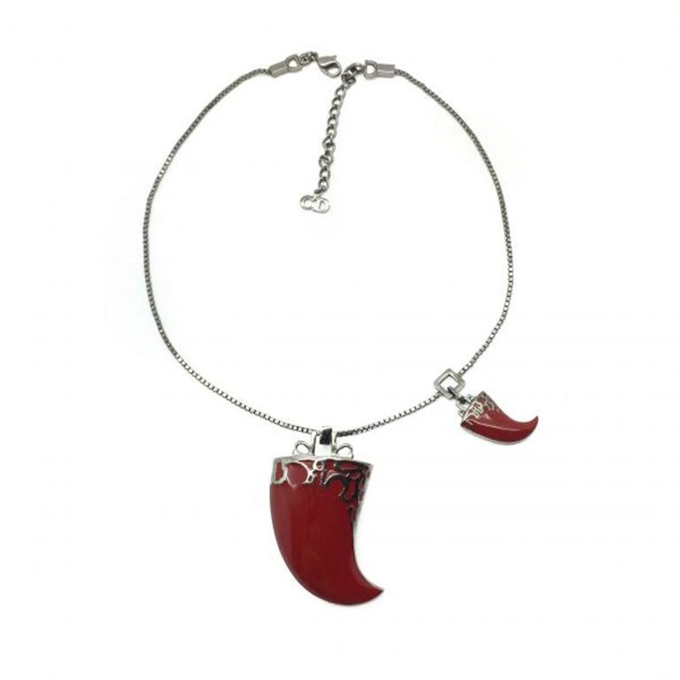 Straight out of the 2003 Dior collection, this John Galliano Claw Necklace is fab and funky. Crafted from blackened silver tone metal and deep red glass enamel, the main events are striking ! A wonderful duo of claw shaped pendants, featuring Dior