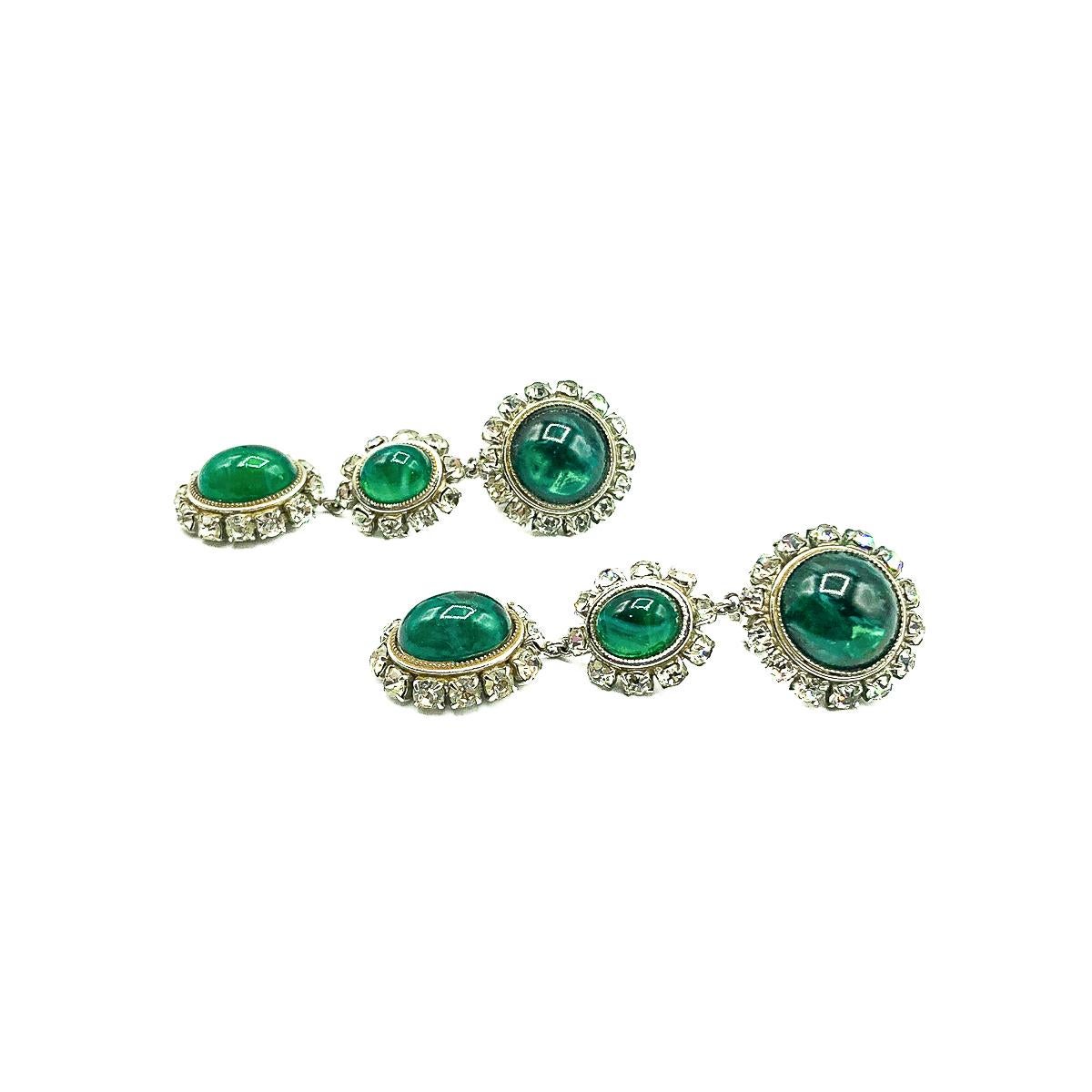 A mesmerisingly beautiful pair of Vintage Dior Emerald Drop Earrings dating to 1966. Featuring wonderful emerald green glass cabochons created to emulate natural emeralds with their inclusions. Set in a silvertone metal. All stones claw or gallery