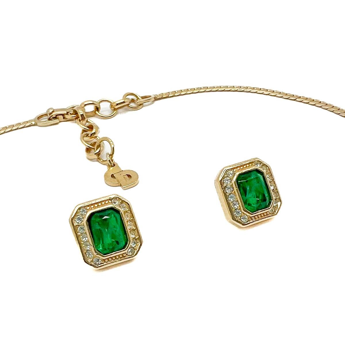 A beautiful Vintage Dior Emerald Necklace and Earring Set. Crafted in gold plated metal and set with adorable emerald crystals surrounded by clear crystal chatons and tapered baguette stones. The necklace is finished with the iconic CD hangtag